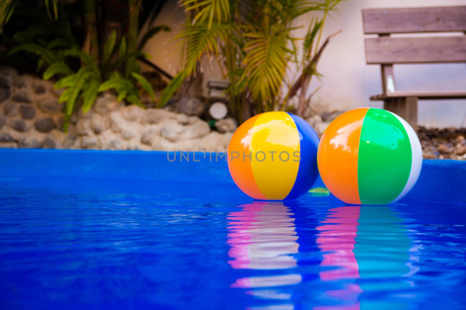 Colorful beach balls floating in pool.

