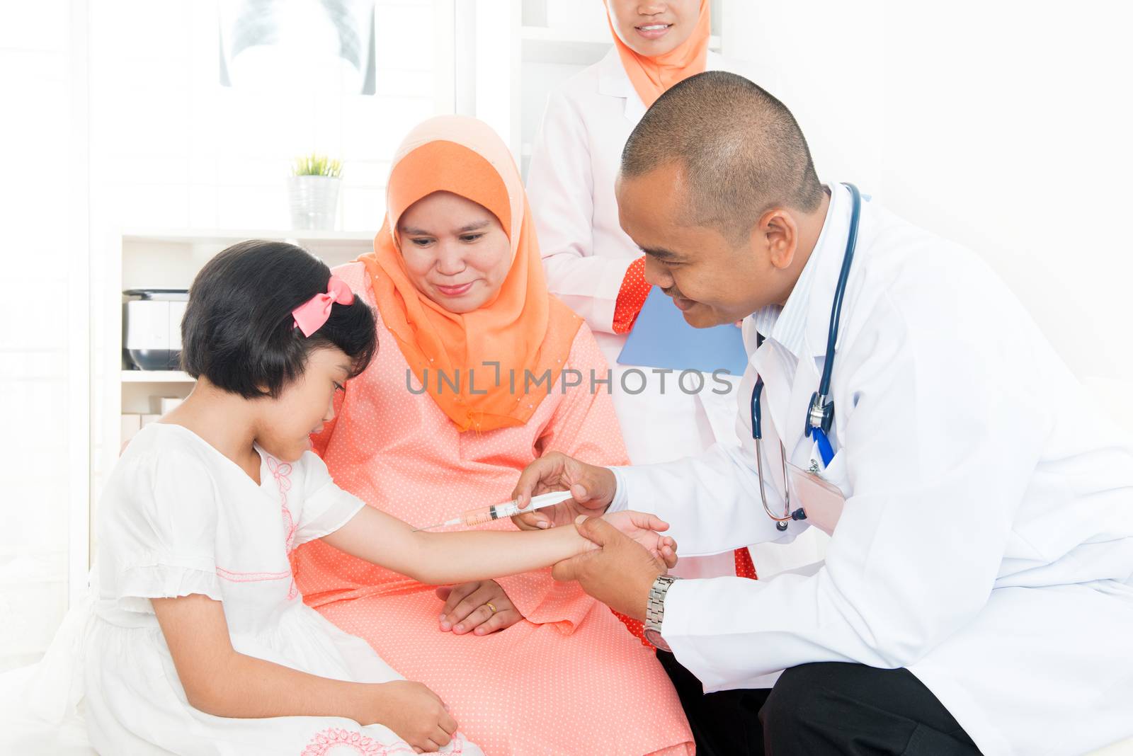 Vaccination concept.  Southeast Asian children receiving vaccine from doctor. Muslim family.