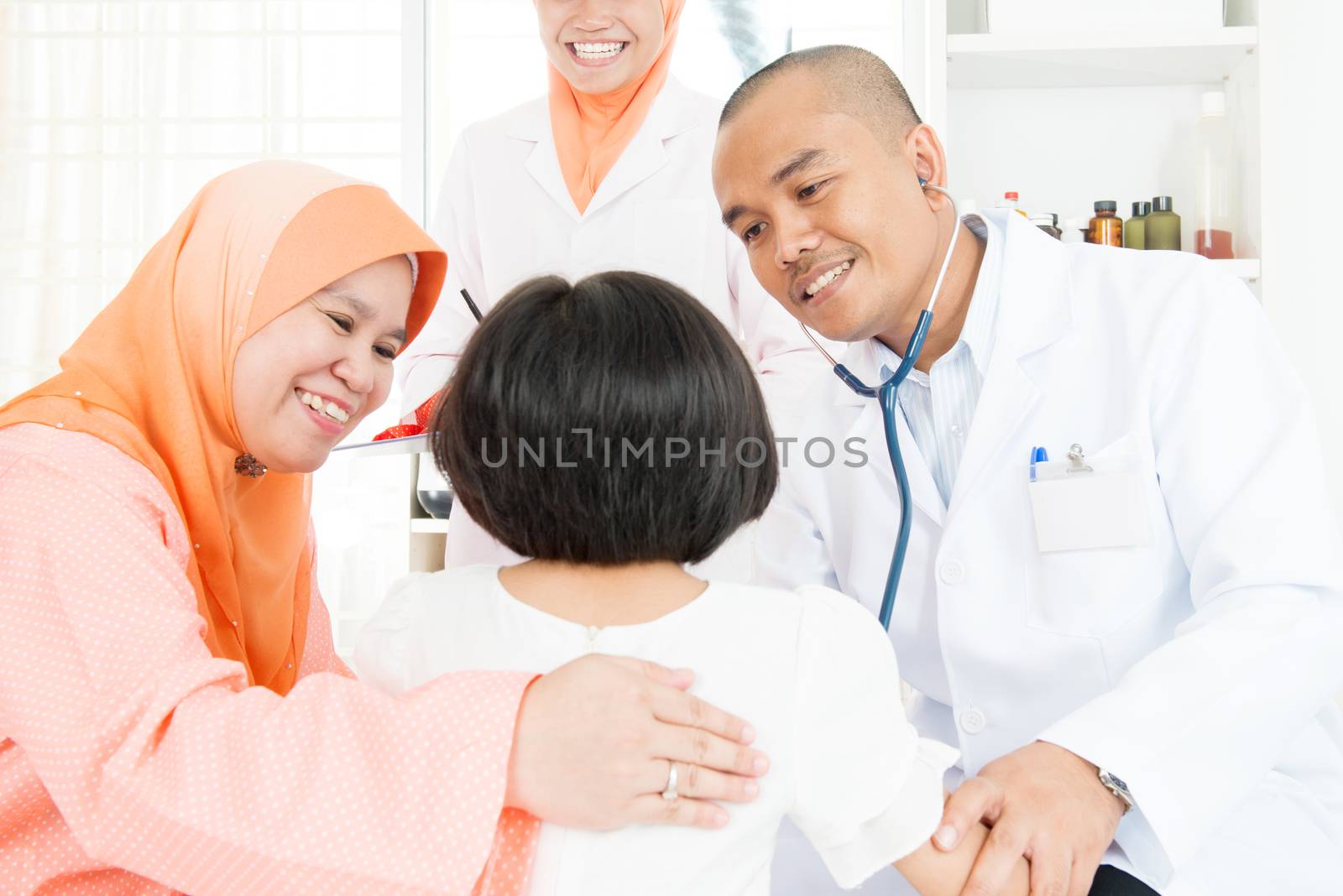 Pediatrician and little Asian girl at hospital.