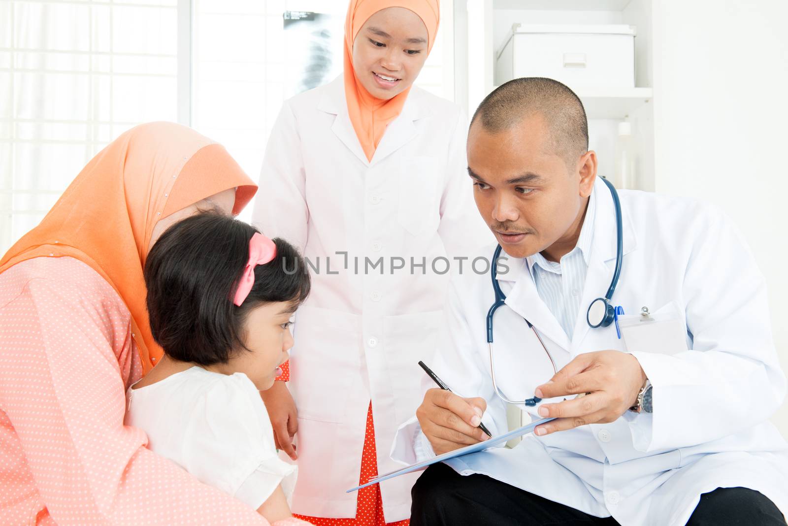 Southeast Asian child and doctor talking in clinics. Muslim family.