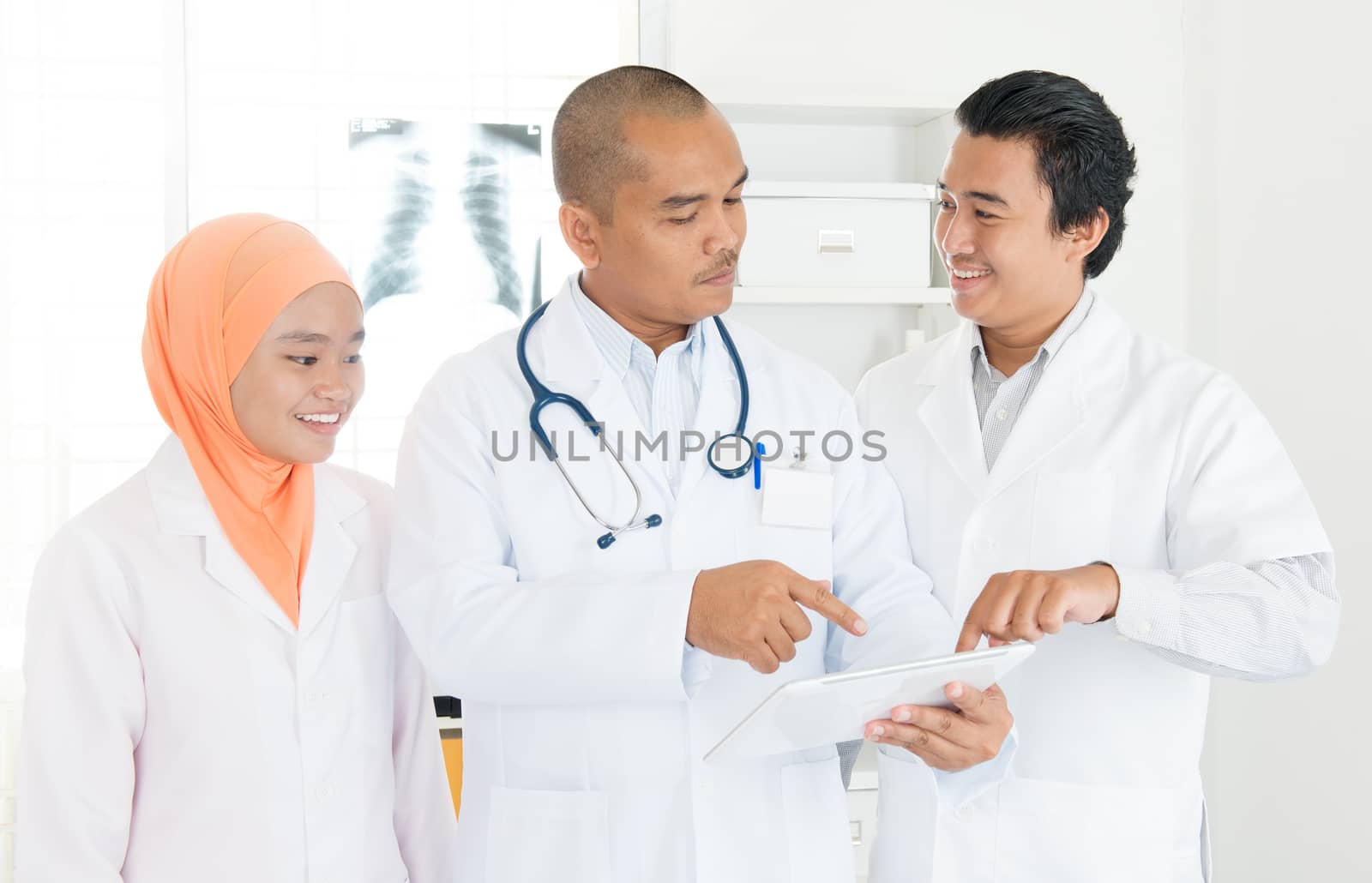 Medical doctors discussing on tablet pc by szefei