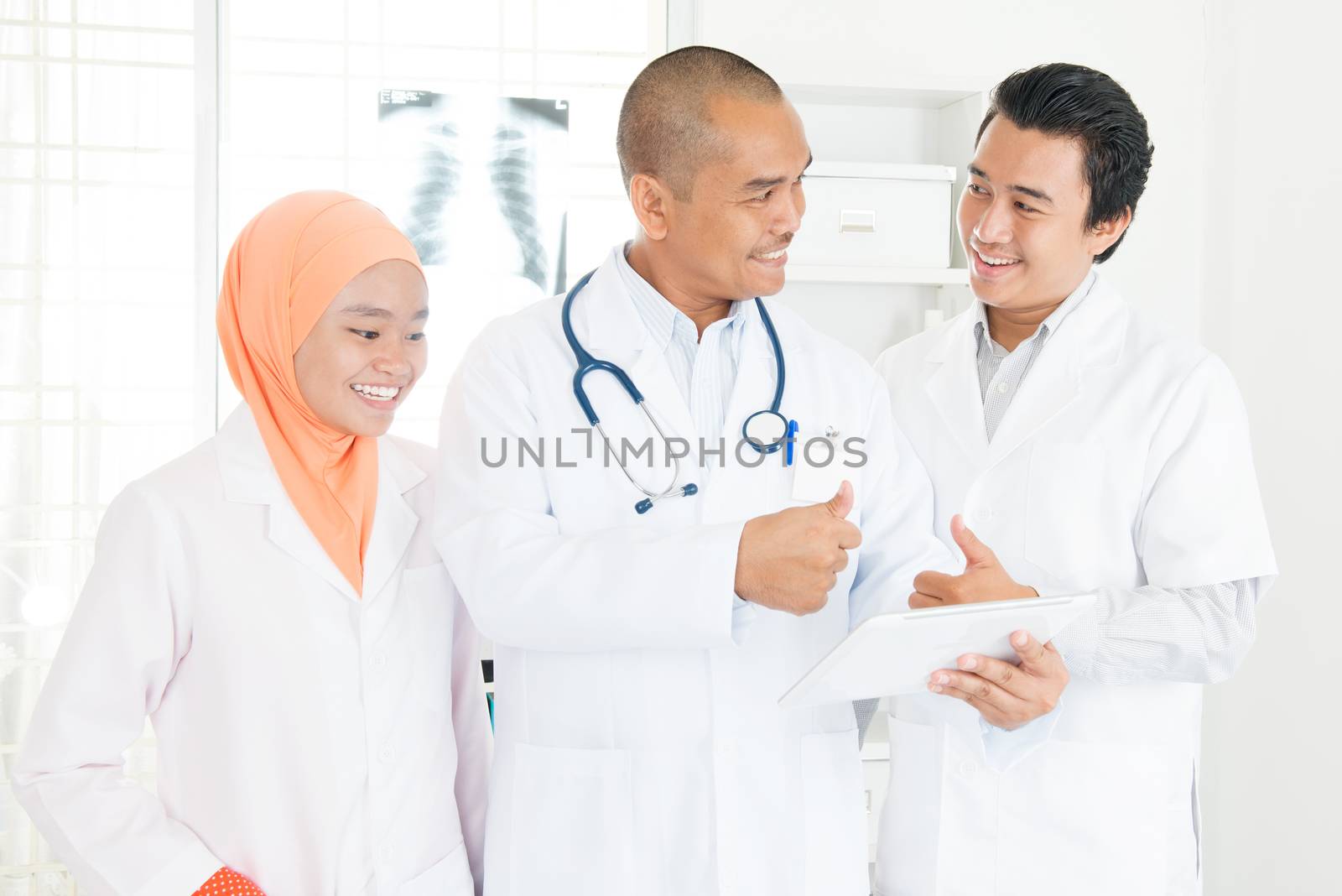 Doctors discussing on tablet pc and thumbs up by szefei