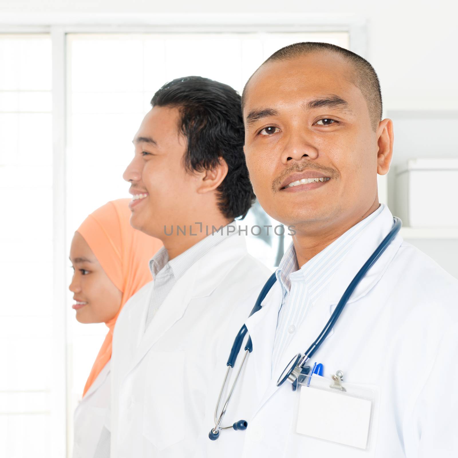 Clinic, profession, people, health care and medicine concept - happy group of Southeast Asian medics or doctors at hospital.