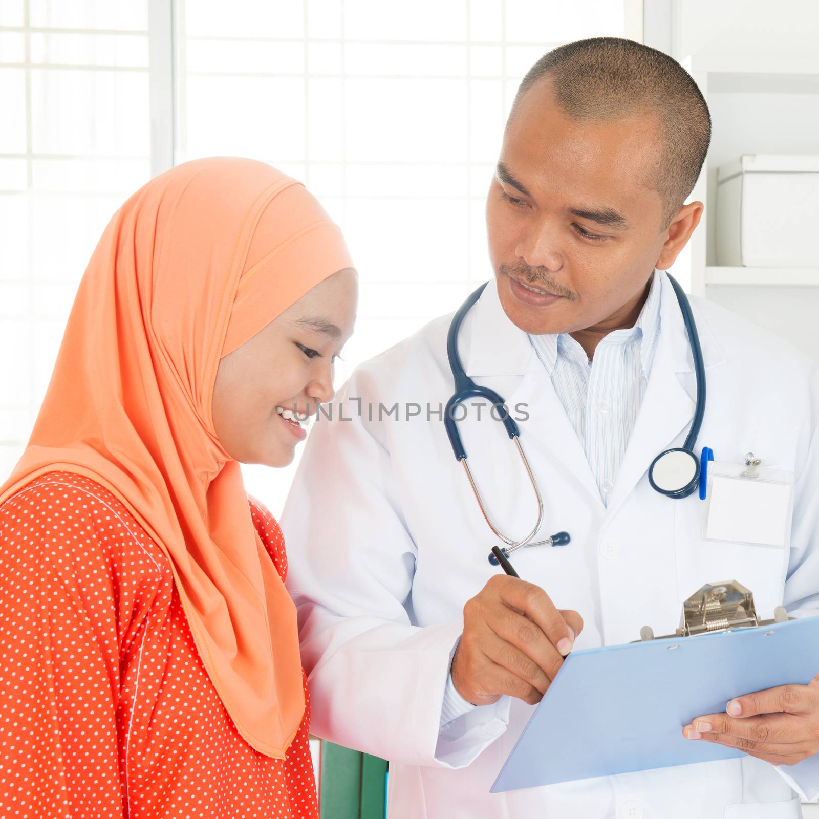 Doctor discussing treatment options with patient. Southeast Asian Muslim people.