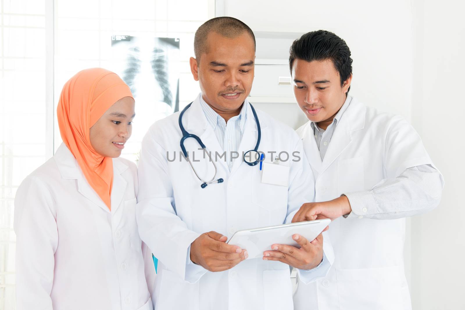 Medical team discussing on tablet pc by szefei