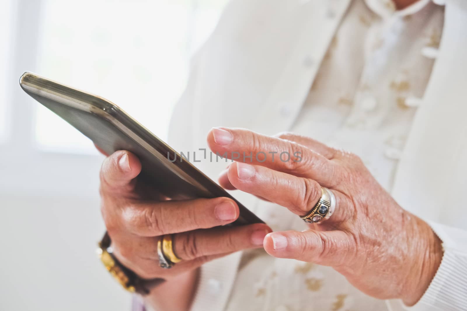 close up image of Senior woman using her mobile phone background.  An idea of modern lifestyle, communication,telecommunication,connectivity, social networking