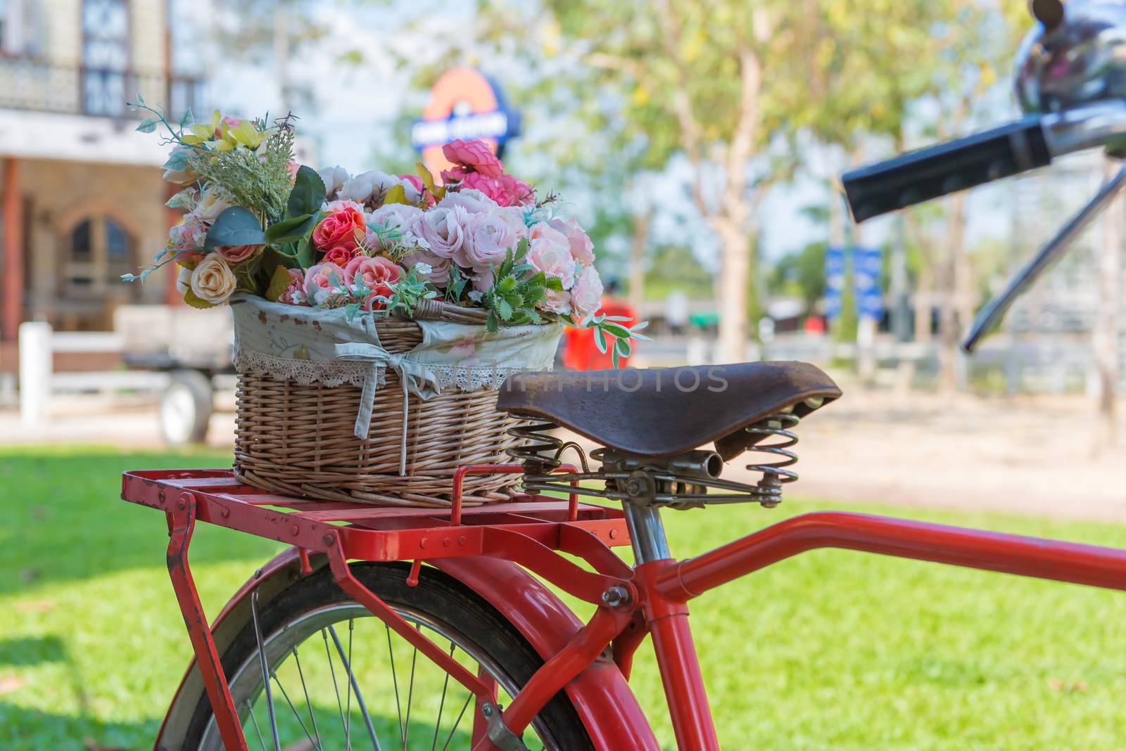 vintage bicycle equipped with basket of flowers in the garden.