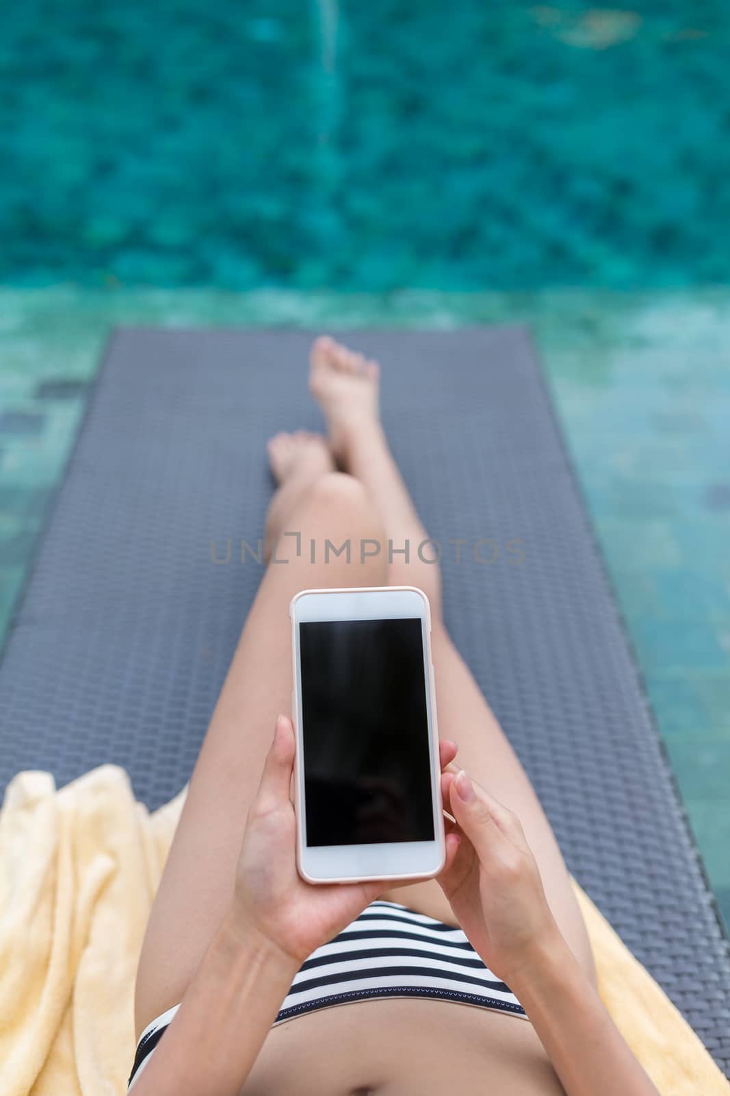 Woman use of mobile phone in swimming pool