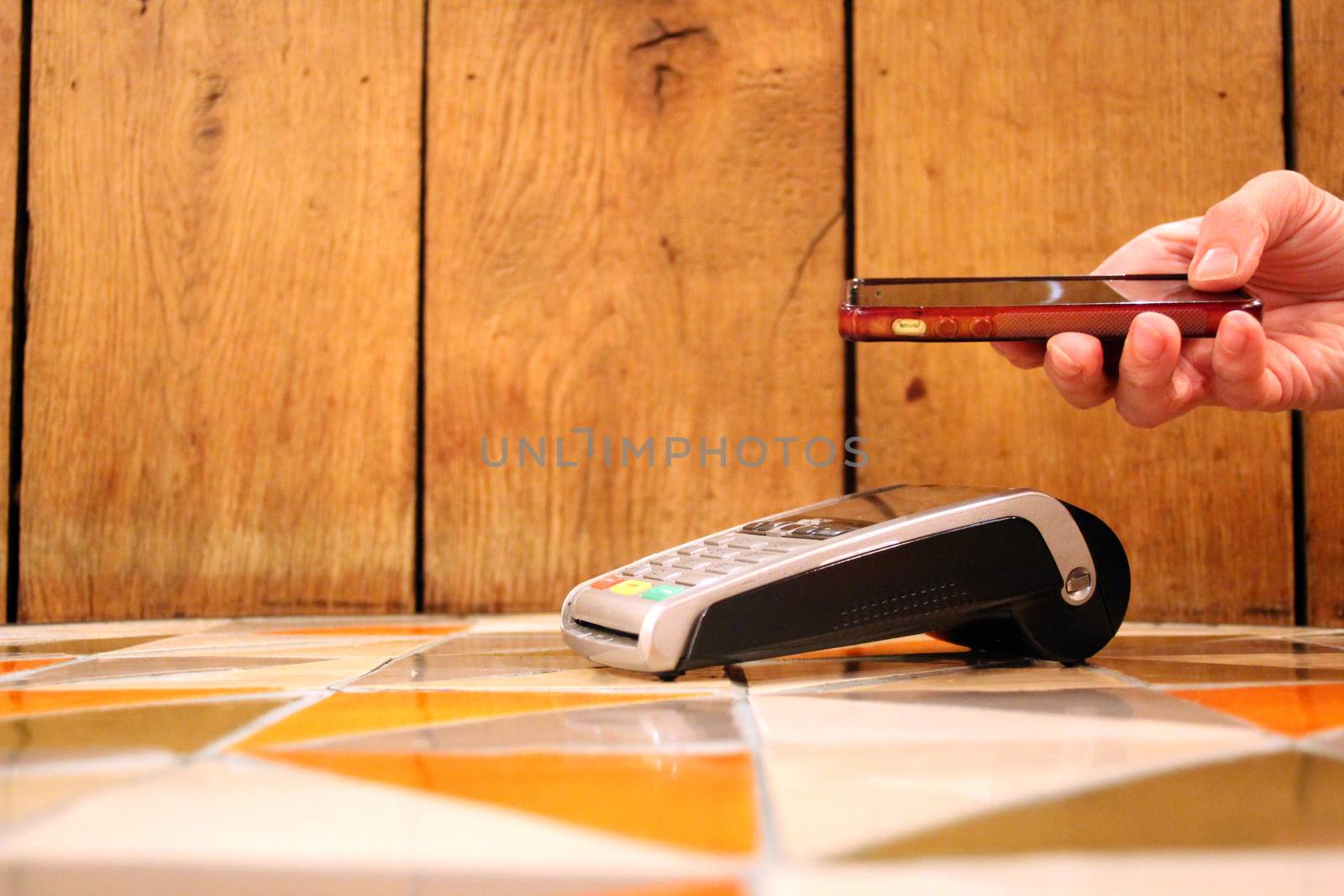 contactless payment phone pdq with hand holding credit card to pay by cheekylorns