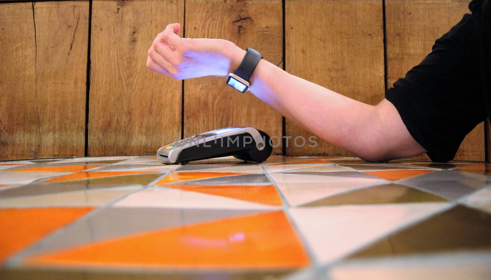 contactless payment apple watch pdq with hand holding credit card to pay by cheekylorns