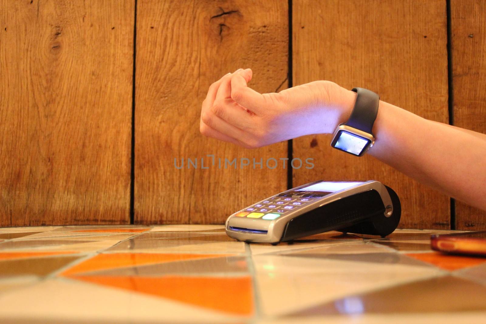 contactless payment watch apple pdq with hand holding credit card ready to pay