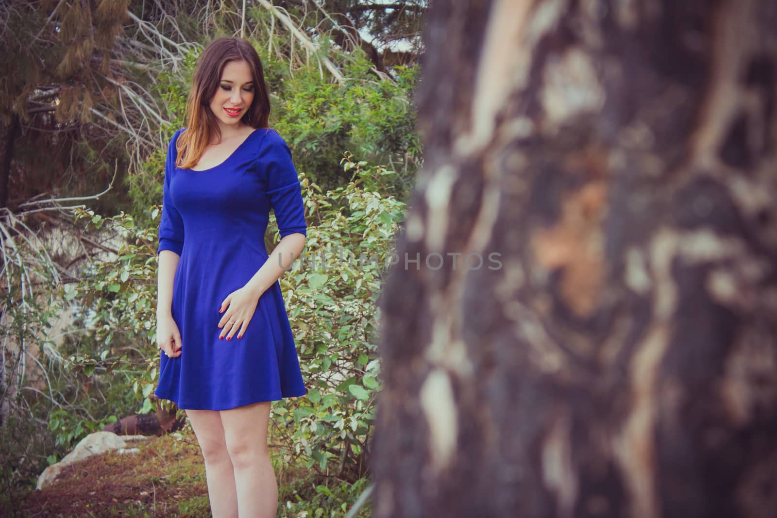 Beautiful young brunette woman posing outdoor at the forest.