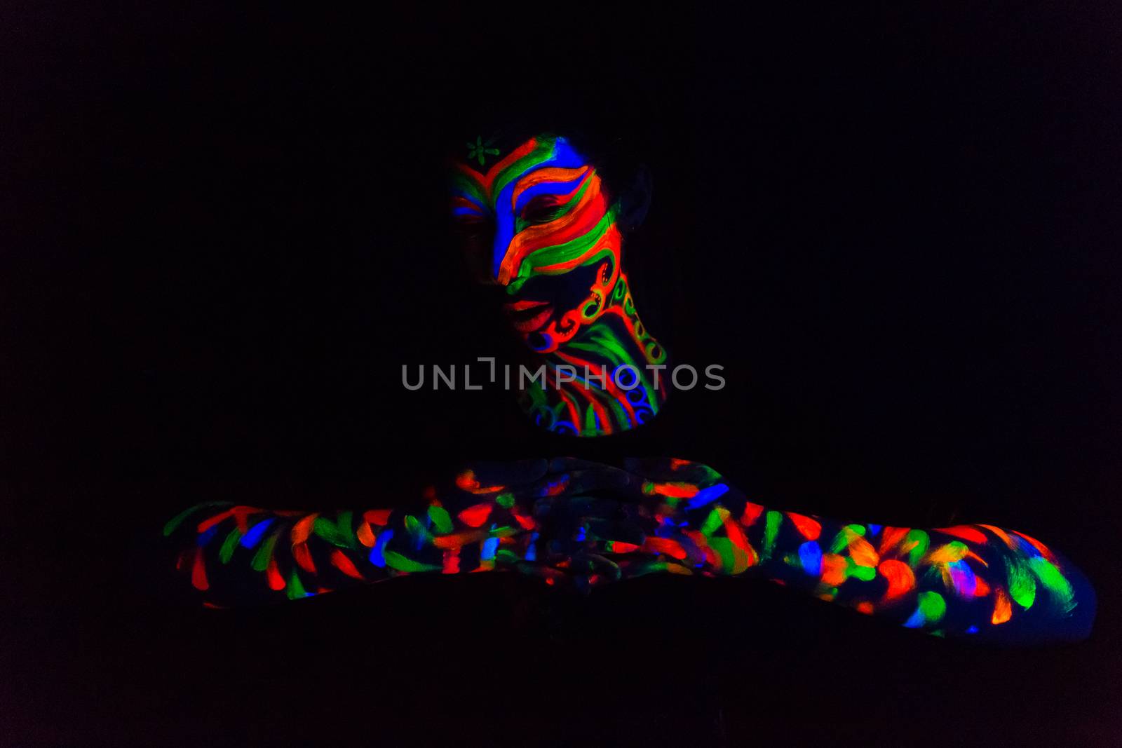 Woman with make up art of glowing UV fluorescent powder.