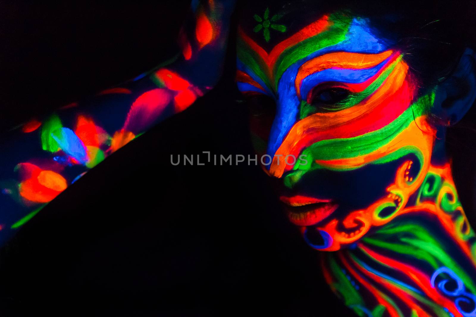 Woman with make up art of glowing UV fluorescent powder.