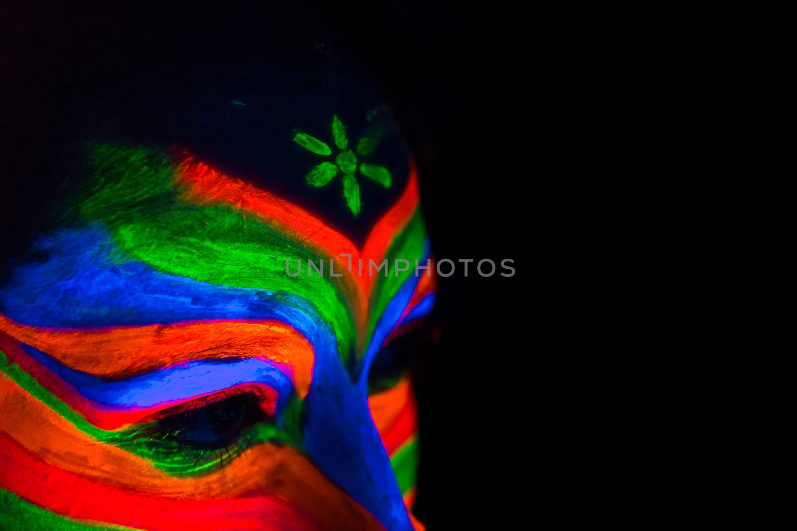 Woman with make up art of glowing UV fluorescent powder.