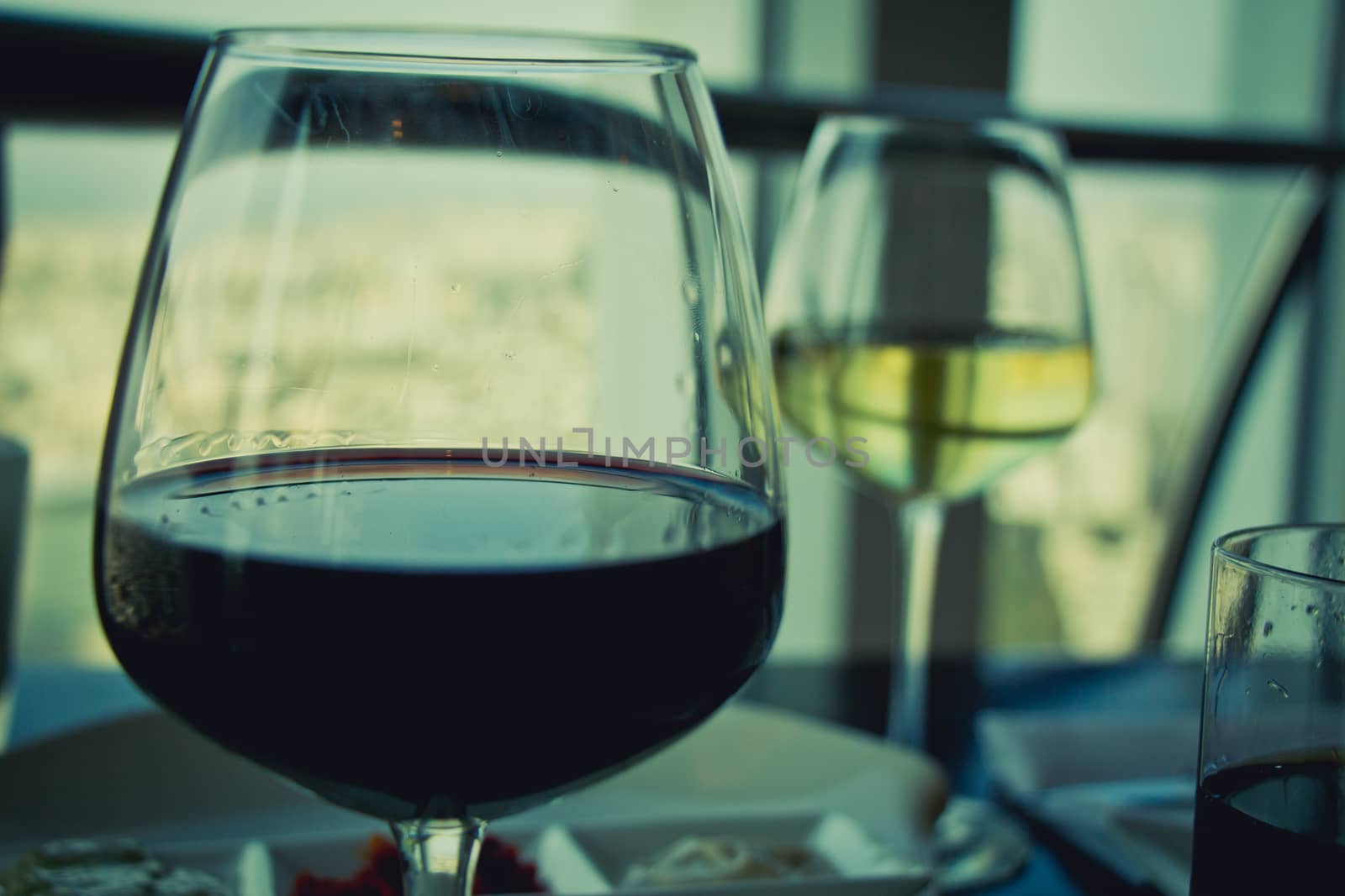 Close up on glasses with red and white wine on white table by wavemovies