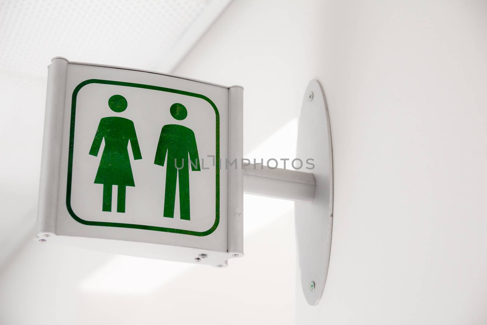 Public modern white and green restroom sign on white wall
Public modern white and green restroom sign on white wall.