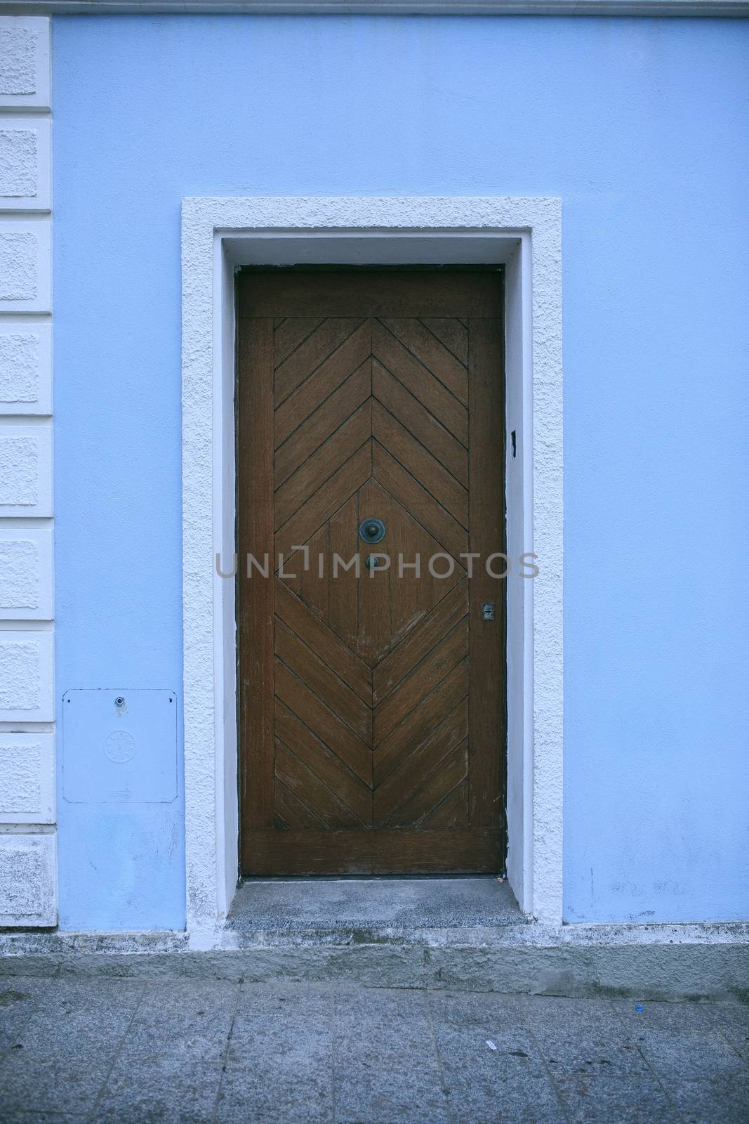 wooden door in a blue building
