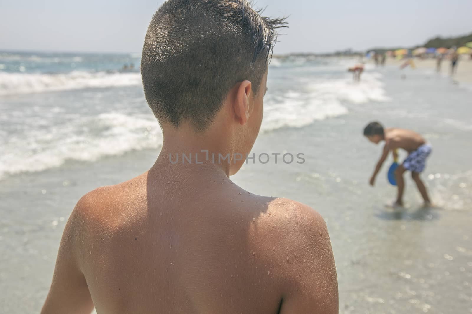 Boy with beautiful green eyes  on the beach