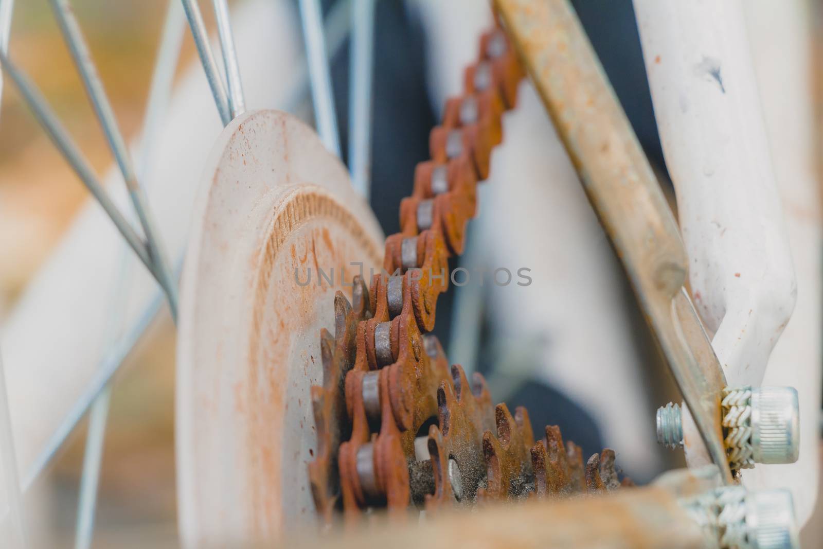 Old rusty chain on white bicycle. Selective focus close up.