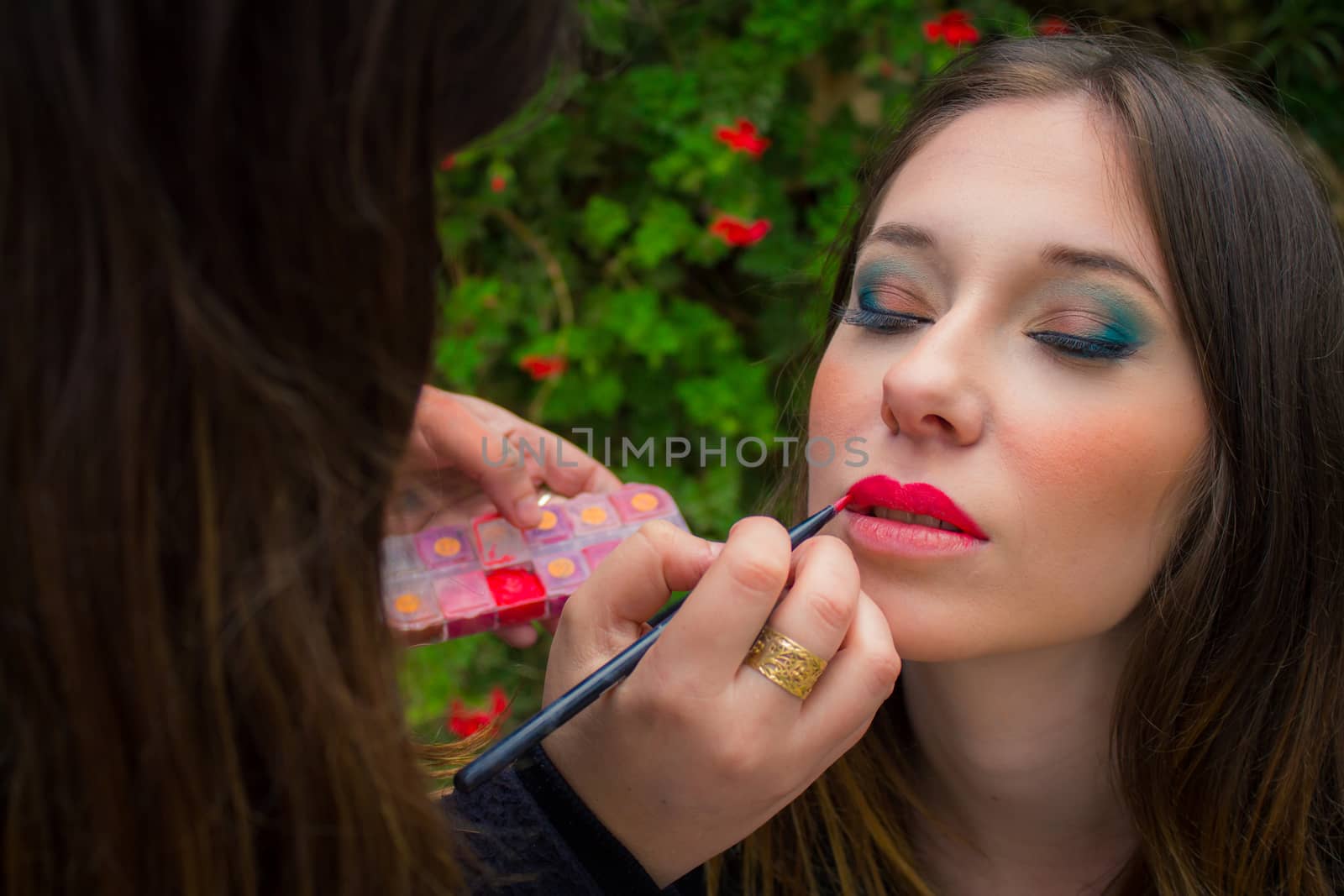 Professional make up artist doing glamour model makeup at work.