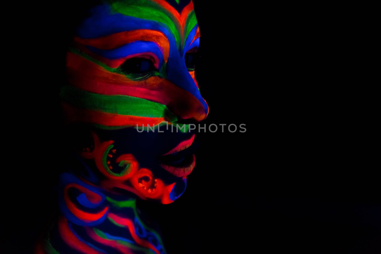 Woman with make up art of glowing UV fluorescent powder.