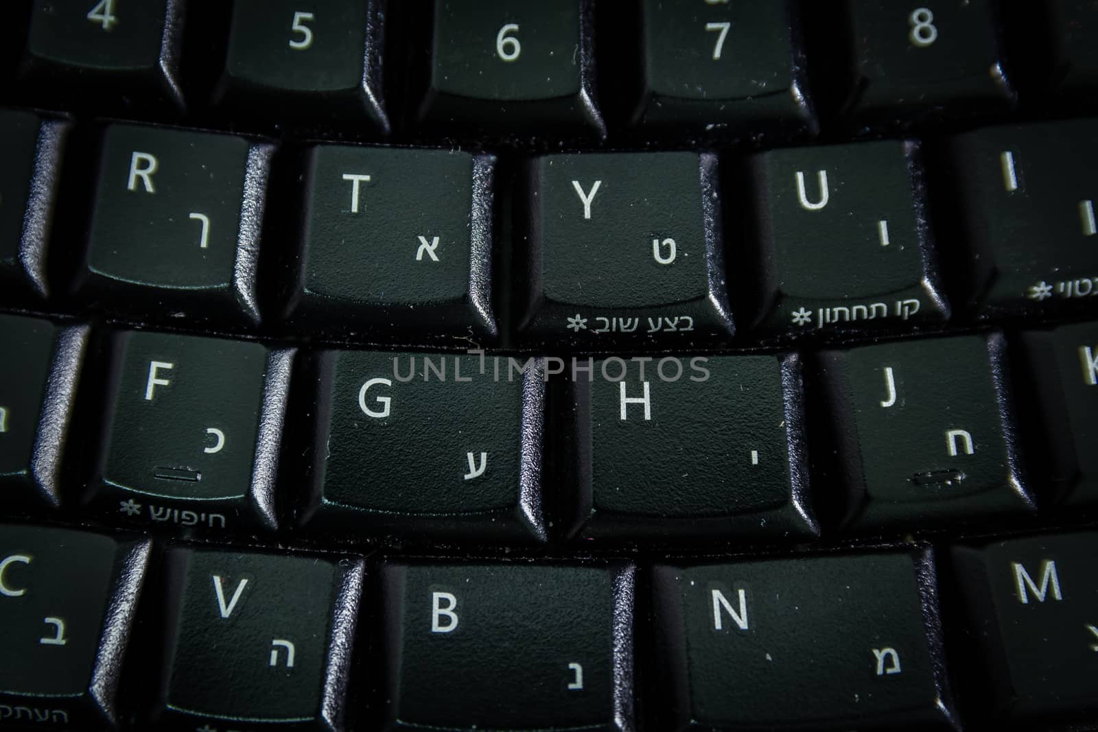 Keyboard with letters in Hebrew and English - Wireless keyboard - Top View - Close up - Dark atmosphere