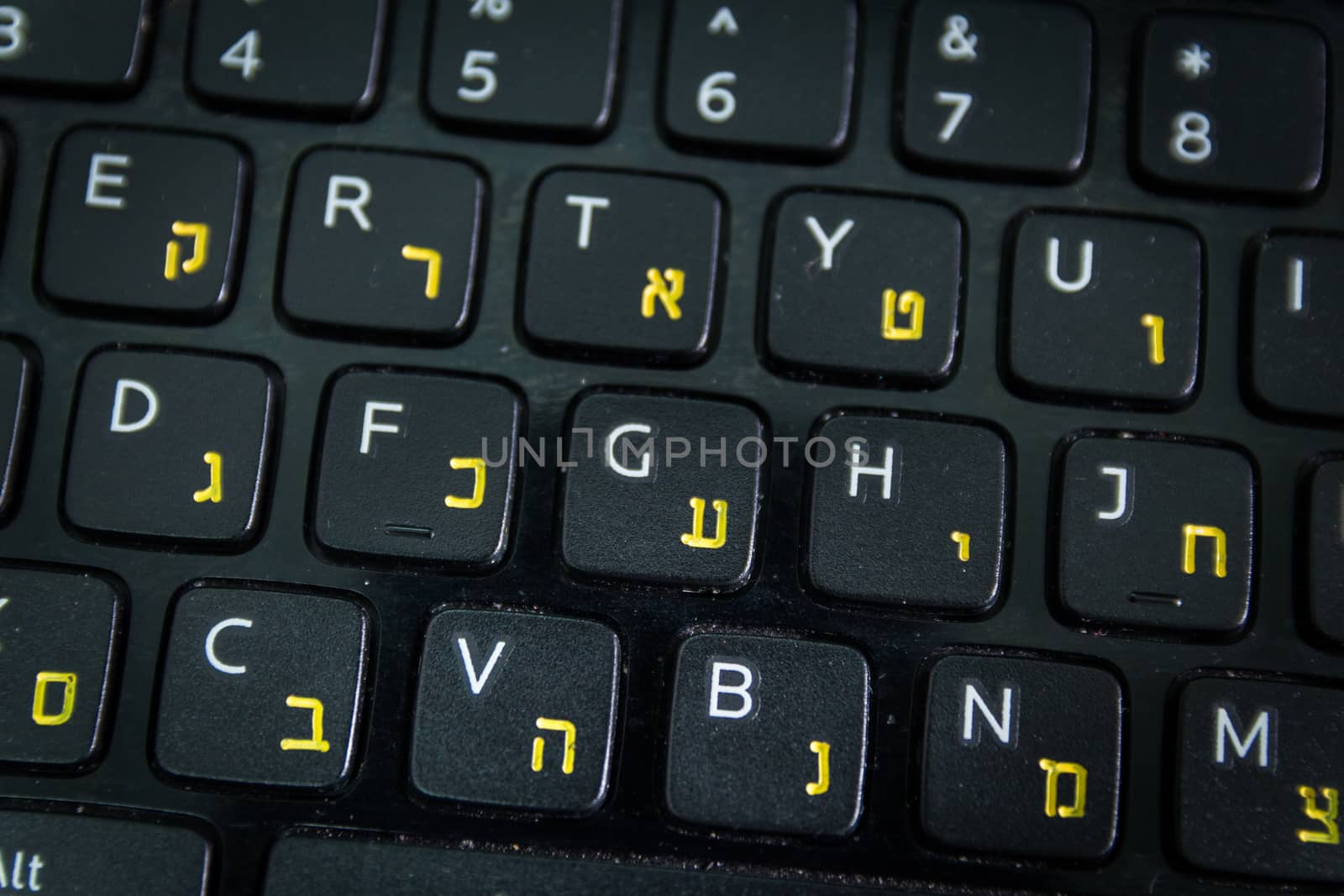 Keyboard with letters in Hebrew and English - Laptop keyboard - Top View - Close up - Dark atmosphere