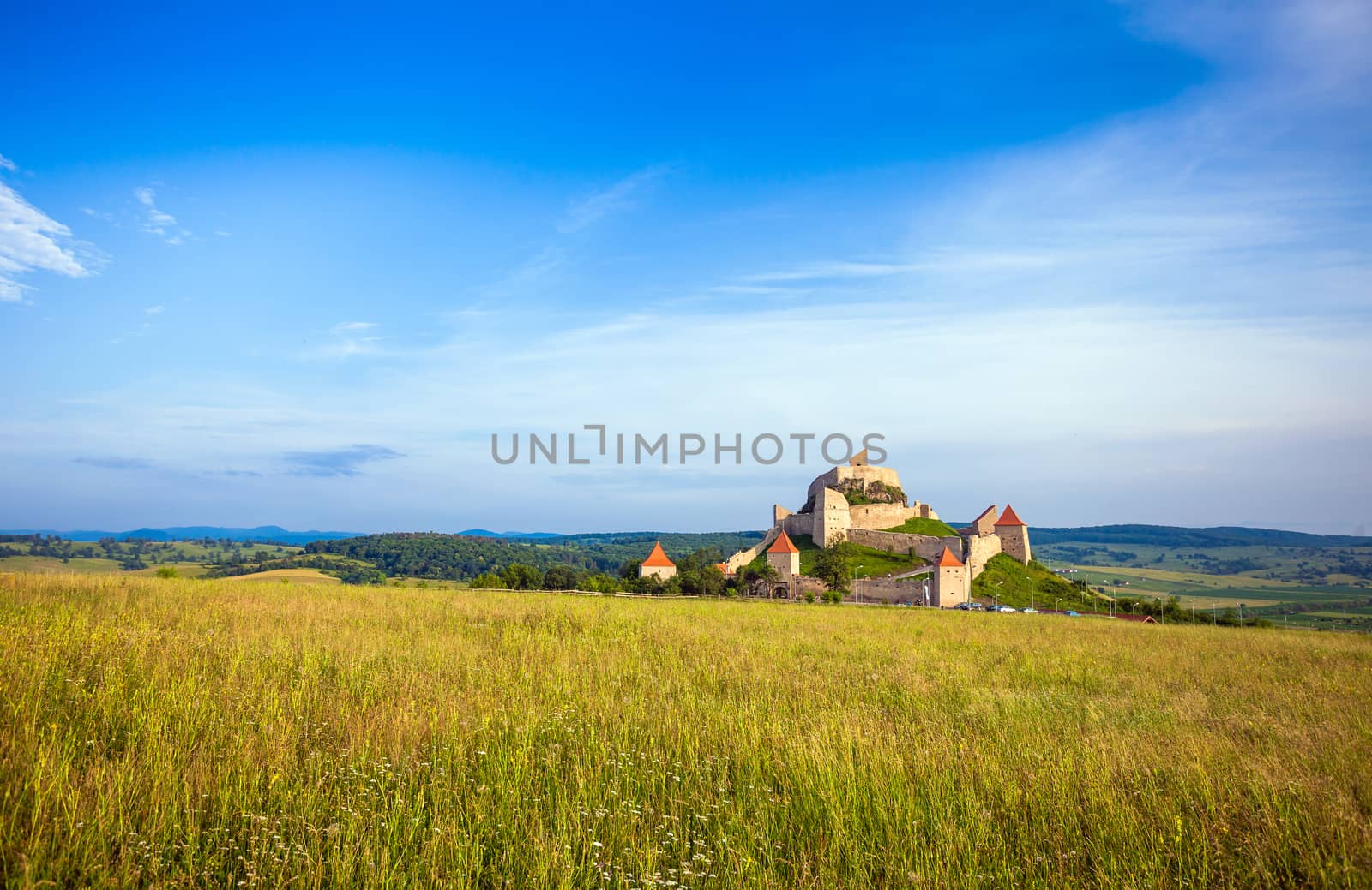 Rupea, Romania - June 23, 2013: Tourists visiting the old medieval fortress on top of the hill, Rupea village located in Transylvania, Romania