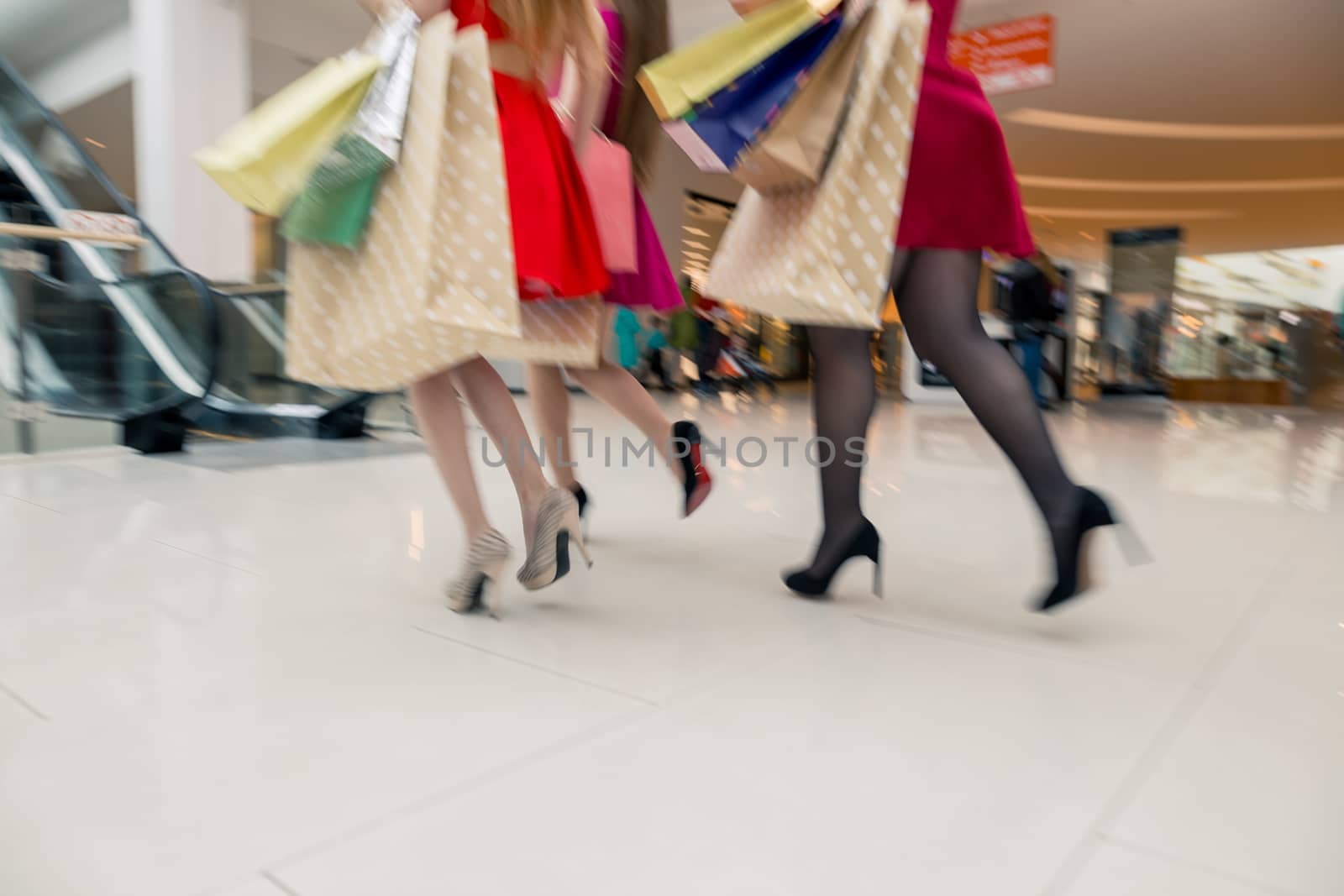 Beautiful girls with shopping bags walking at the mall