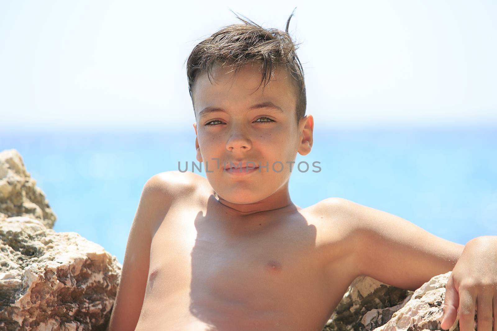 Boy with beautiful green eyes on the beach