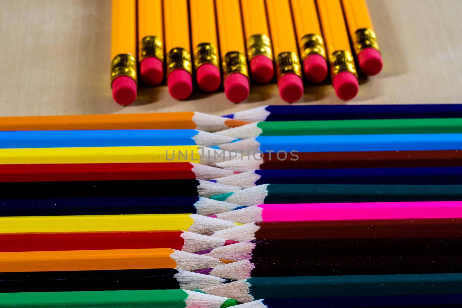 Beautiful and colorful pencil crayons. Wooden table. Black background.