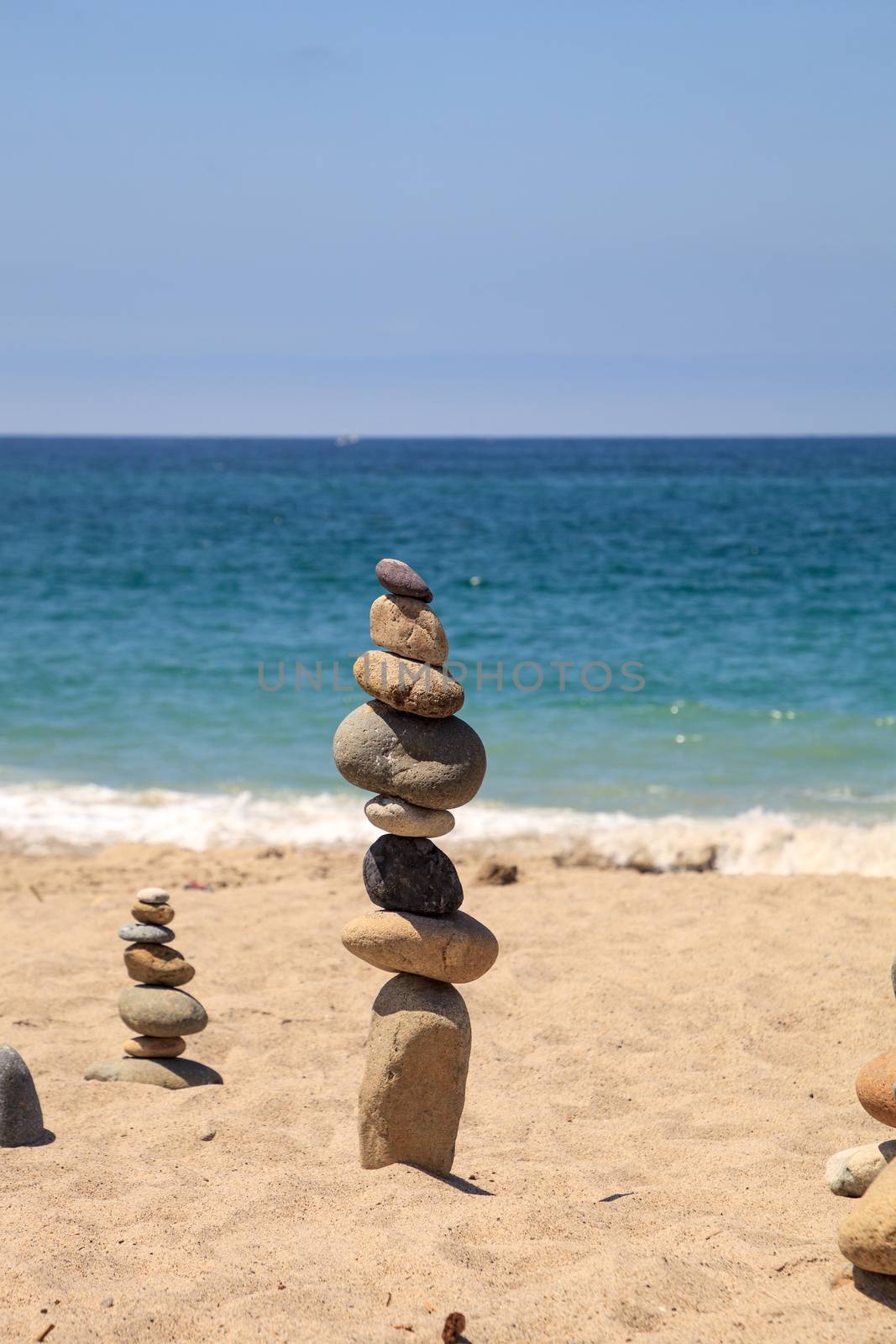 Stones piled on top of one another in Inuksuk fashion in summer at the San Clemente State Beach in Southern California