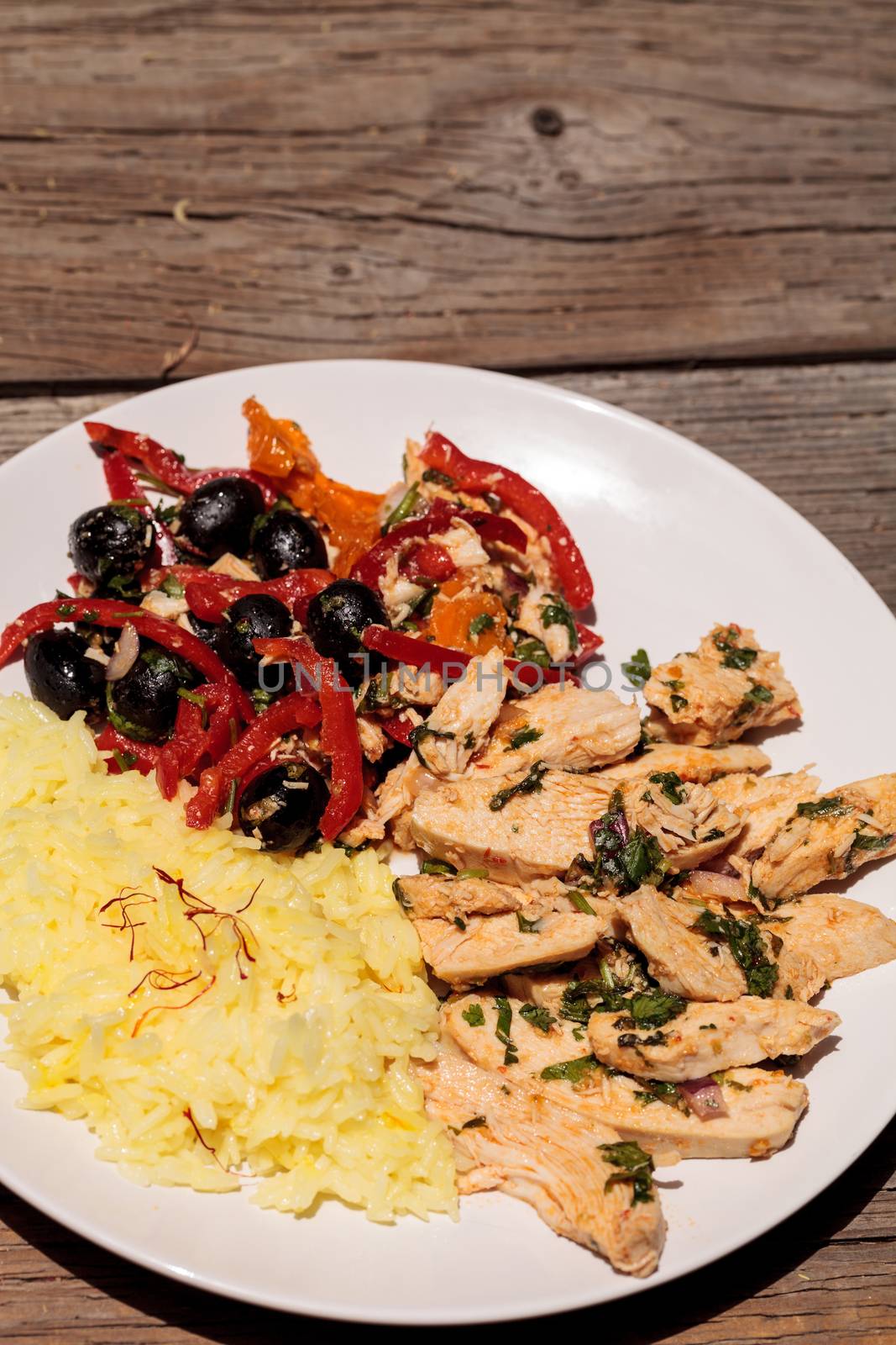 Spicy Chicken Diablo with cilantro, olives, peppers, garlic and onion served over saffron yellow rice.