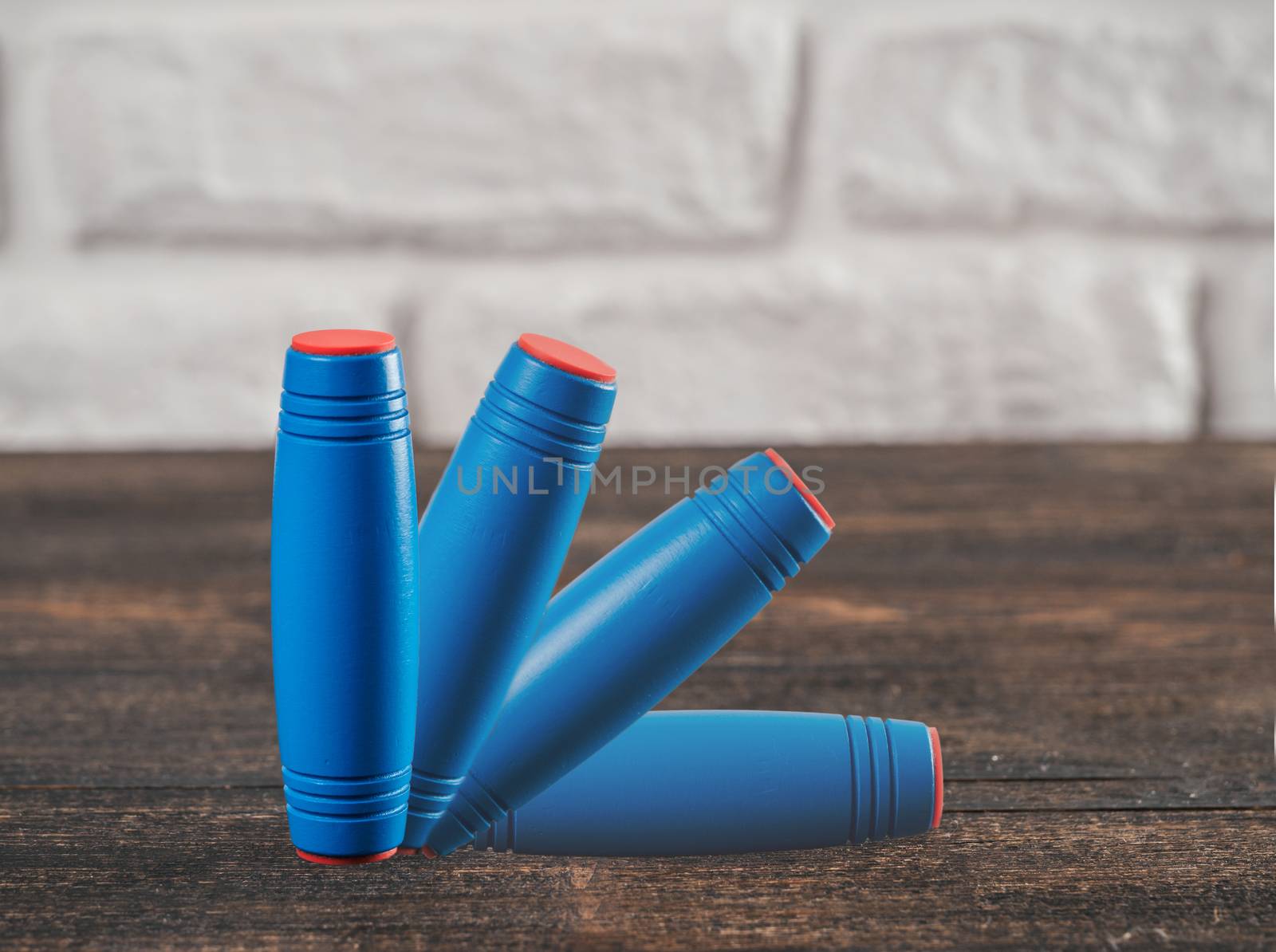 Fidget rolling Stick Toy flip blue color. Imitation movement on brown table background. Copy space.