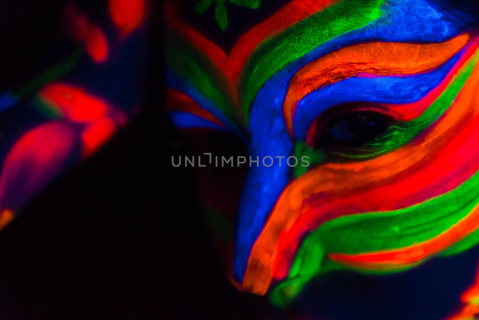 Woman with make up art of glowing UV fluorescent powder.