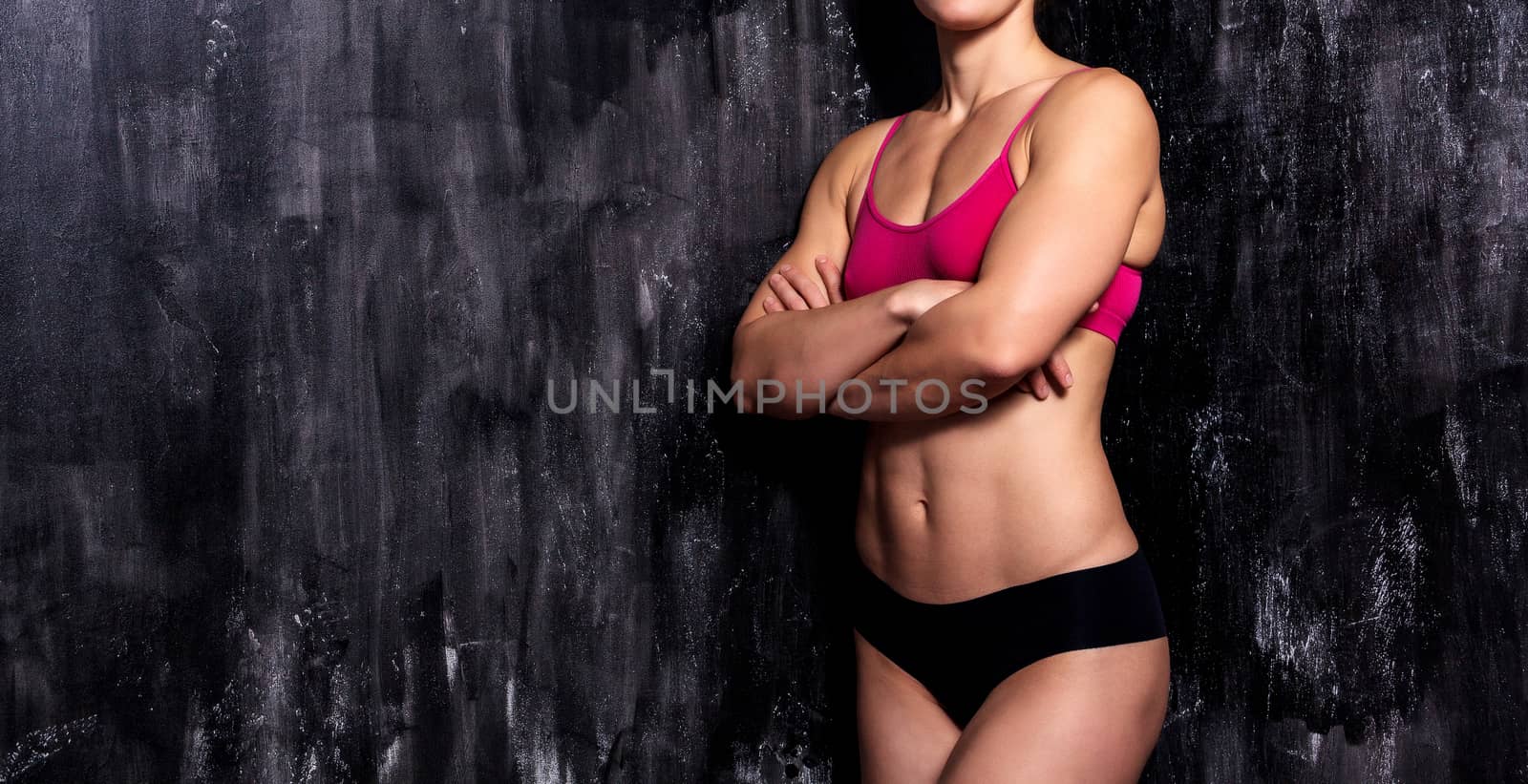 Strong fitness woman with on dark background by Nobilior