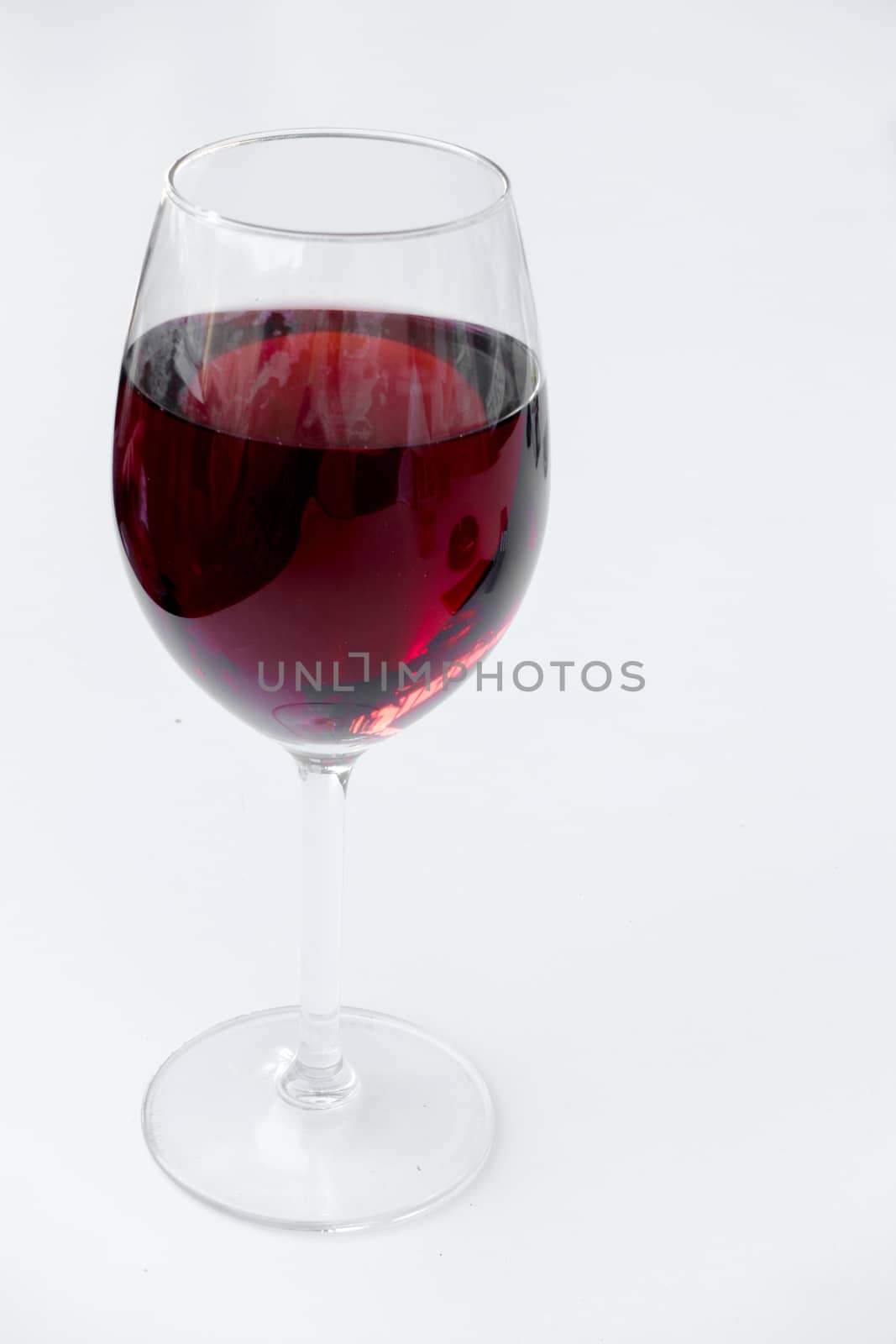 Red wine in a glass isolated on white background - realistic photo image, shot from slightly above