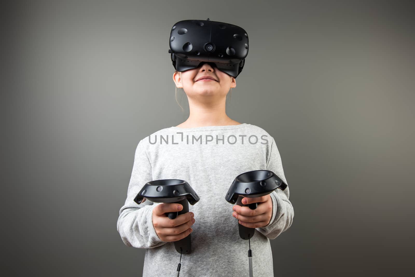 Child with virtual reality headset and joystick playing video games by ufabizphoto