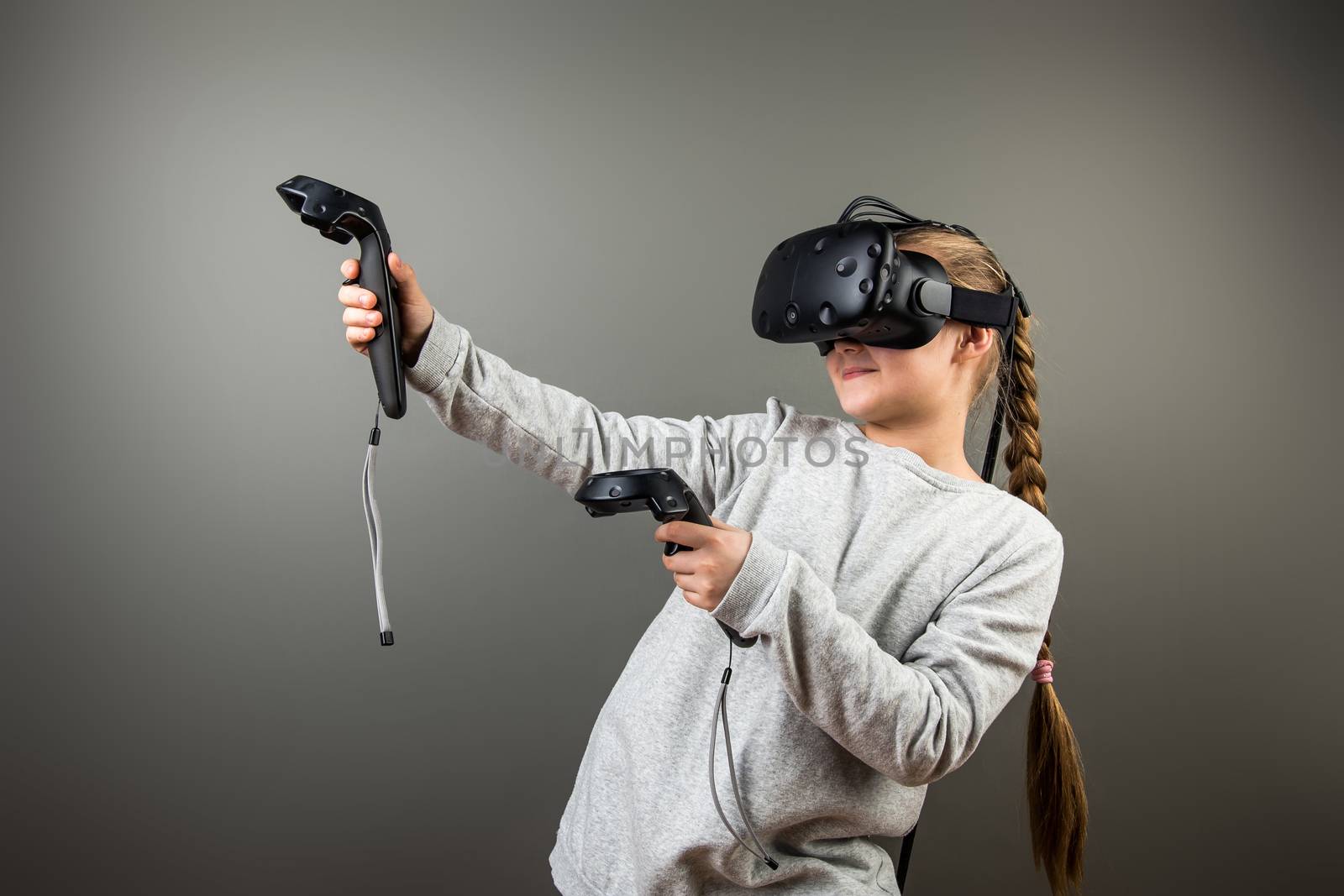 Child with virtual reality headset and joystick playing video games by ufabizphoto