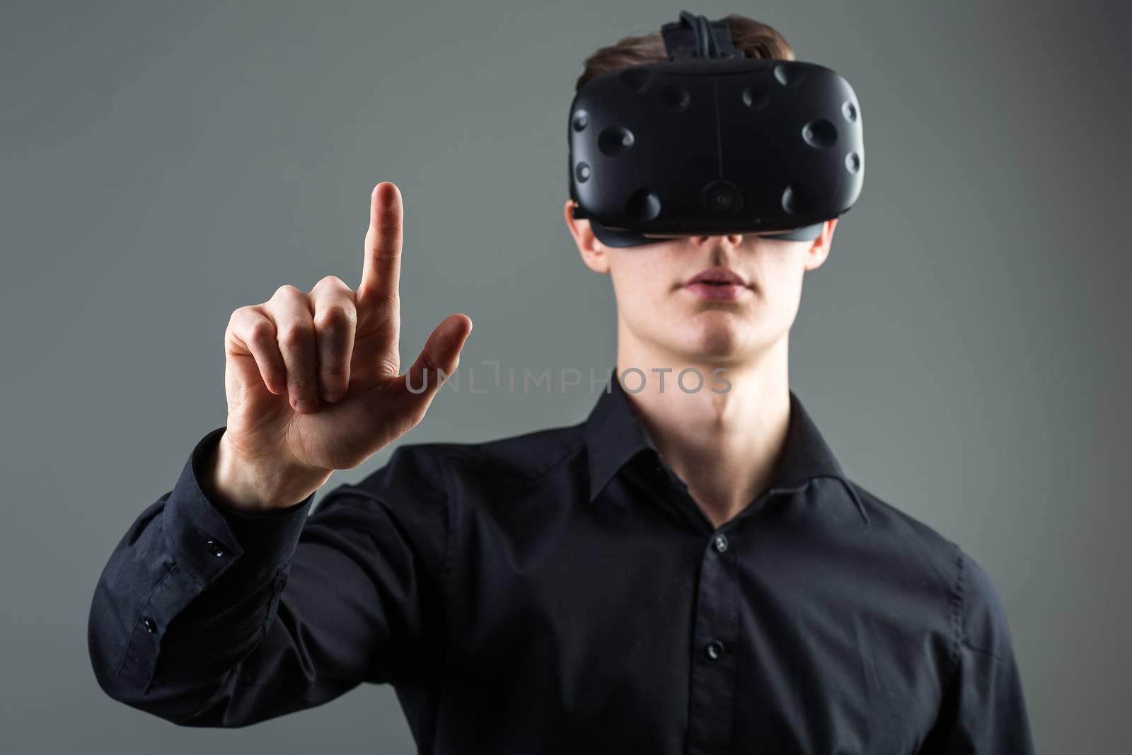 Closeup of male hand.young man wearing virtual reality goggles. Smartphone using with VR headset by ufabizphoto