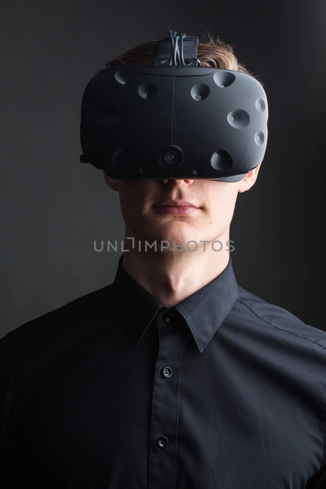 Man wearing virtual reality goggles. Studio shot, gray backgroun by ufabizphoto