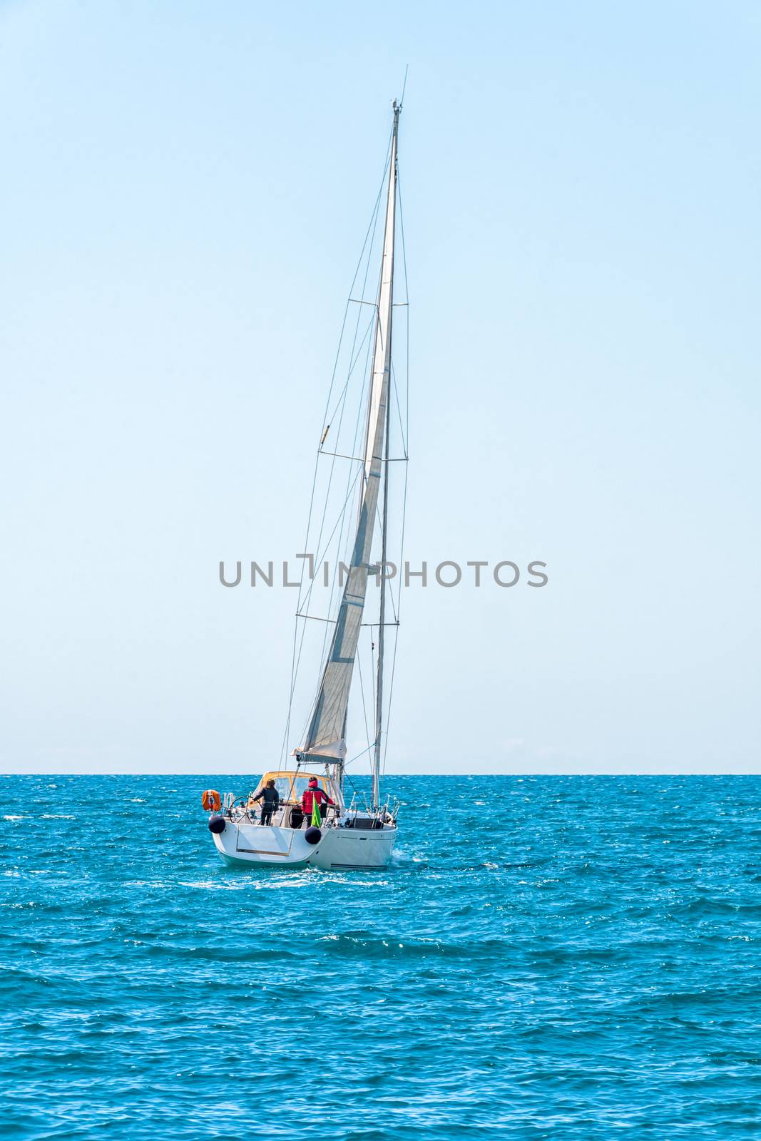 Sailing ship yachts with white sails in the open Sea, sailing boat on horizon, shot from behind