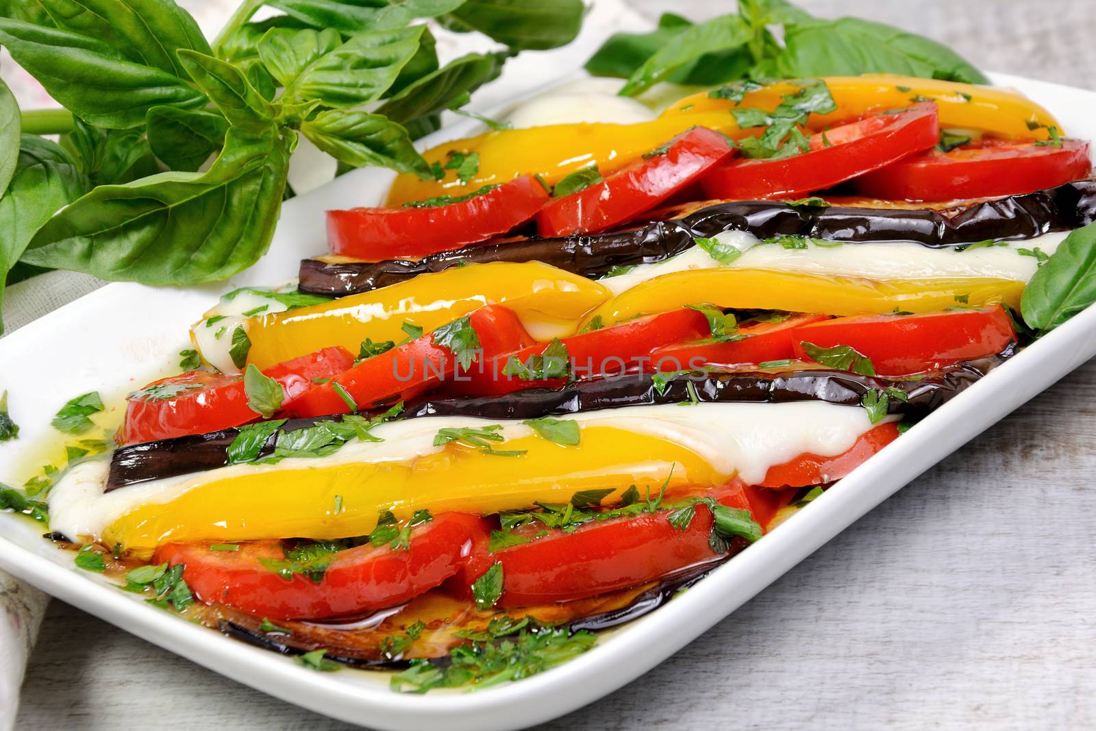 Baked eggplants with tomatoes, yellow pepper and slices  mozzarella 