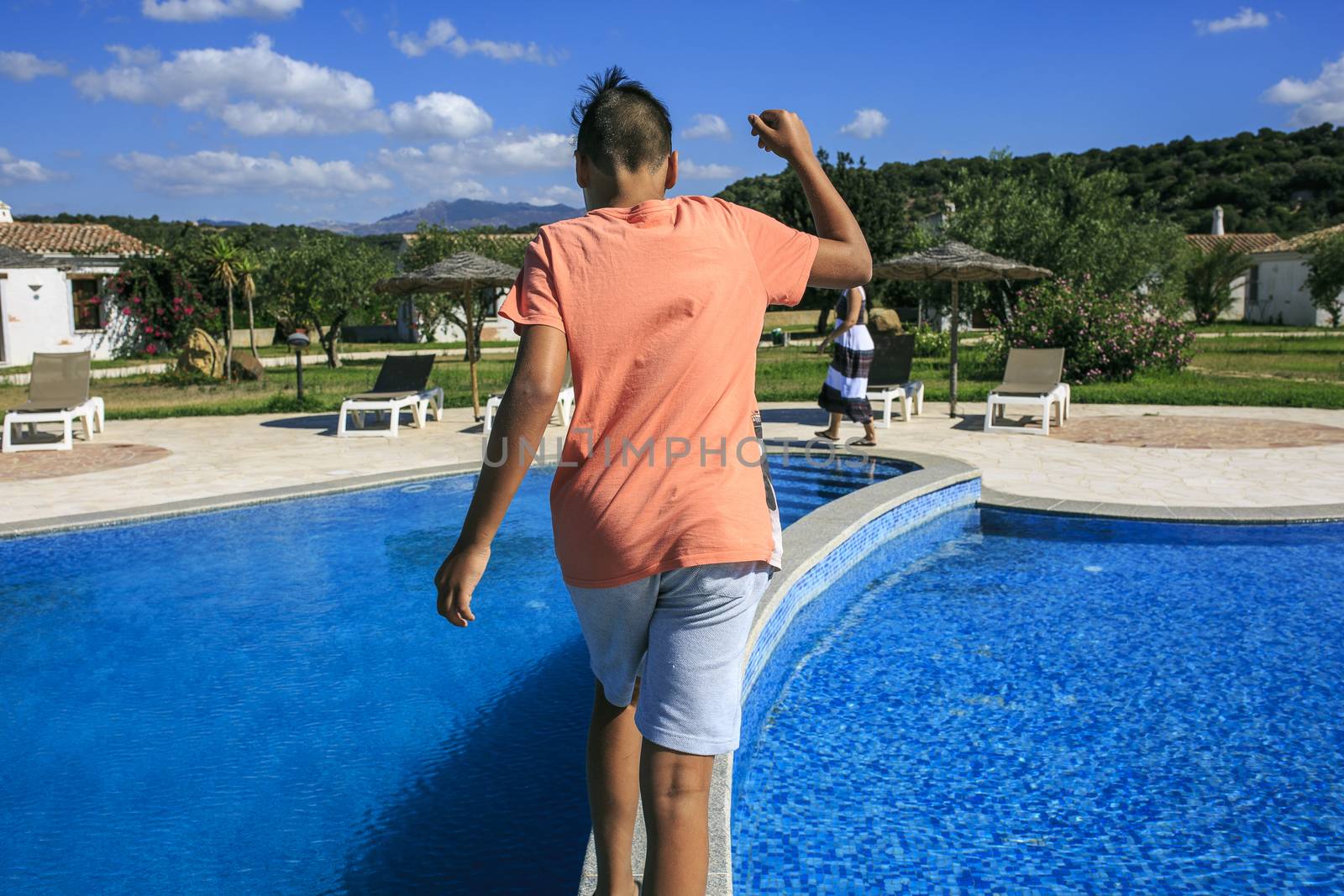 Boy  walking over the swimming pool