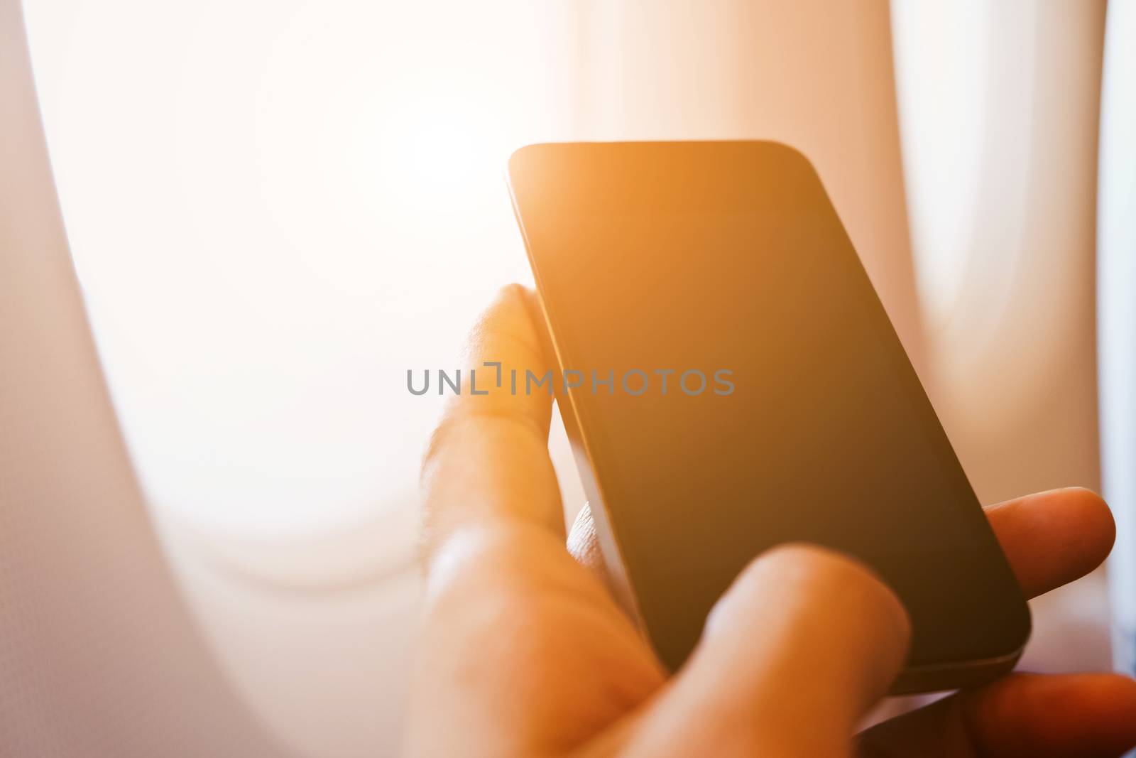 close up of business man sit in airplane watching his cell phone, Doing business the modern way concept background