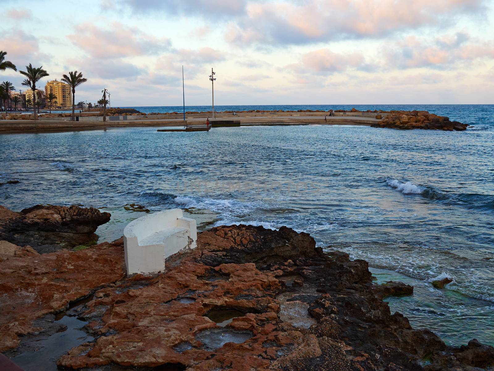 Bench made of stone in beautiful Torrevieja beach, Costa Blanca, by Ronyzmbow