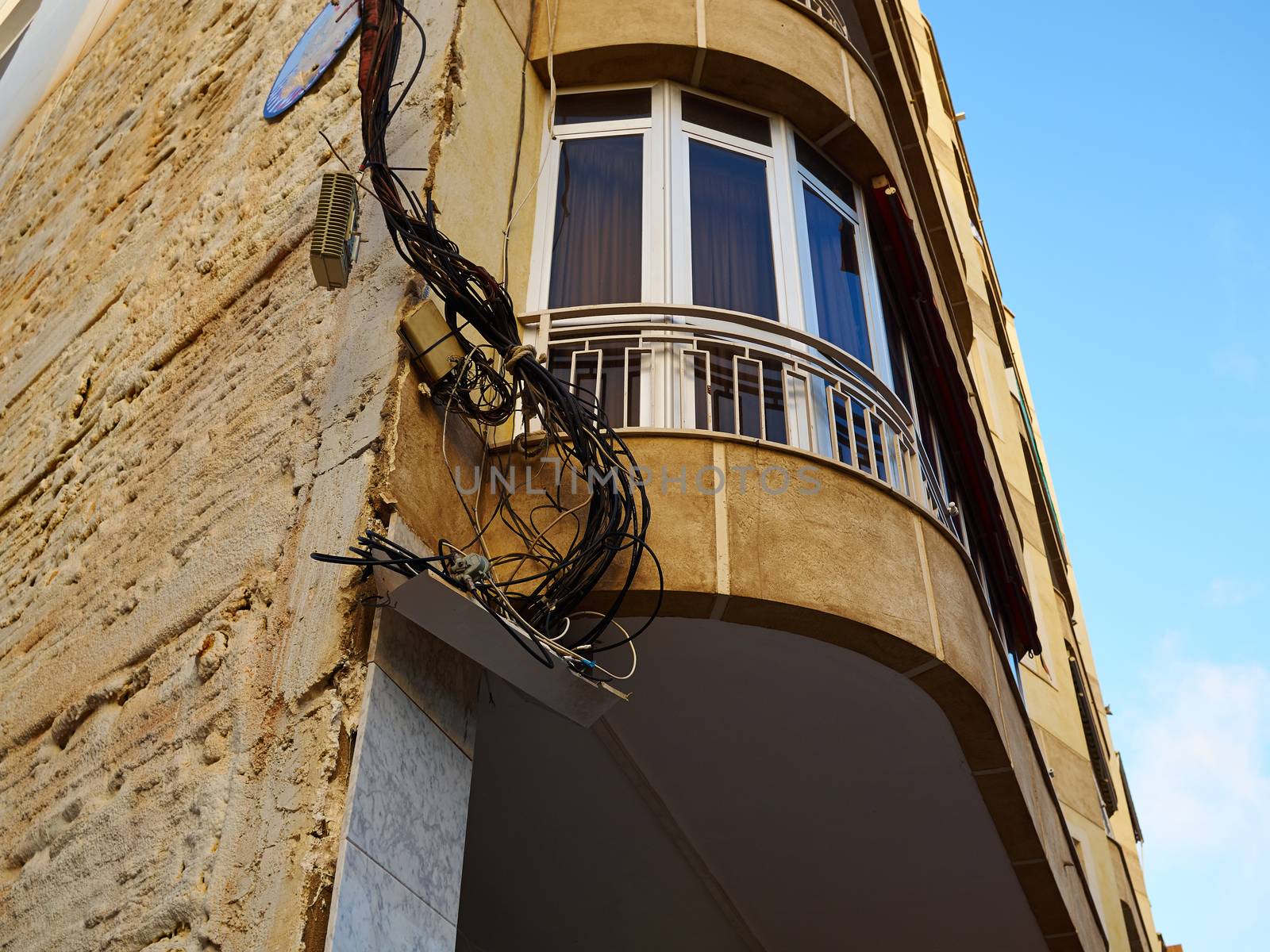 Tangled electric cable mess on a wall of building 