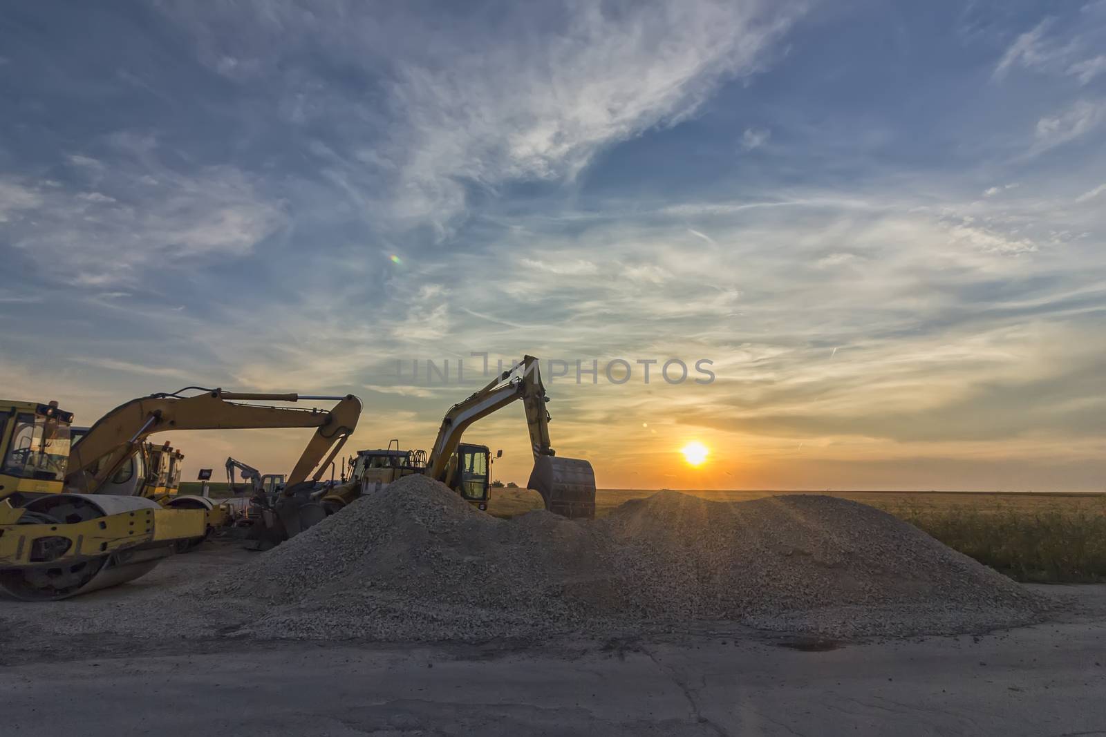 excavators in construction site at stunning sunset