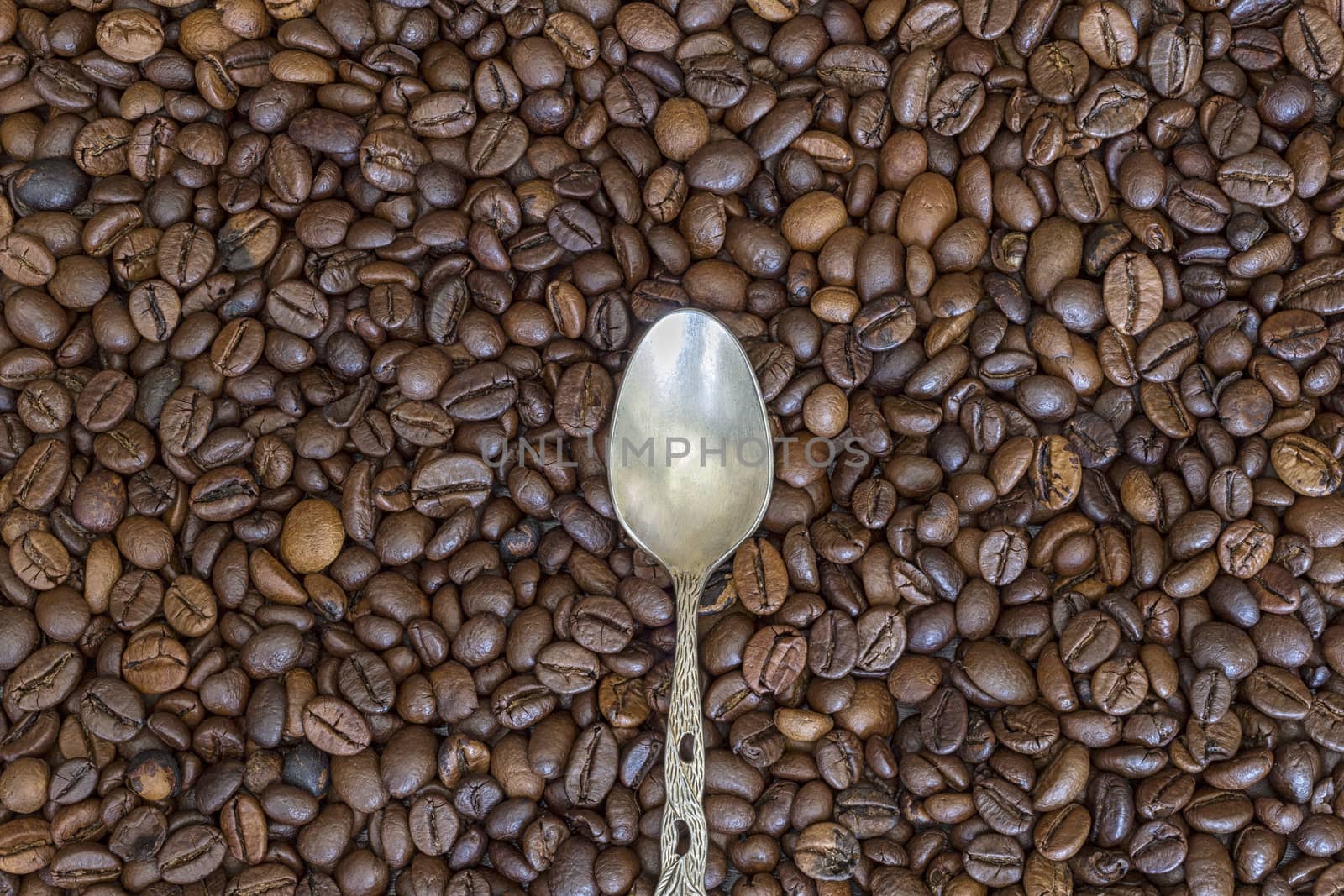 silver spoon and coffee beans as the background